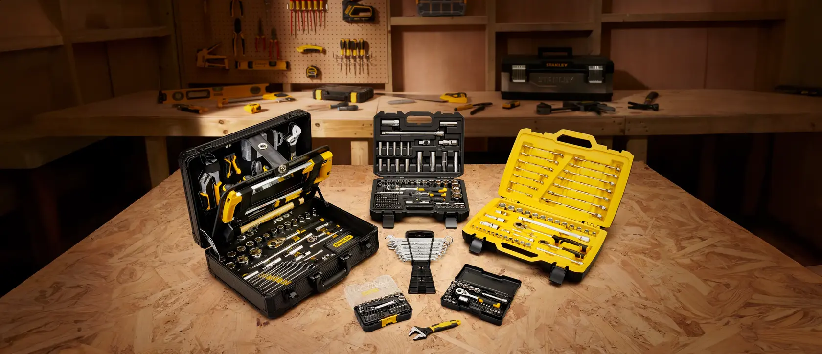 STANLEY FMMT82827-1 juegos de herramientas en estuches negro y amarillo sobre mesa de taller, foto frontal.