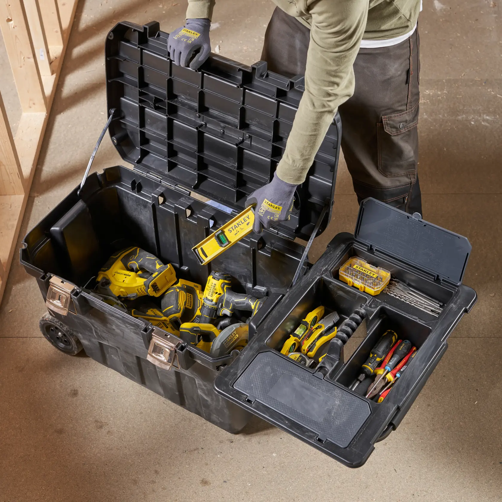 Caja de herramientas STANLEY 1-92-978 abierta con herramientas manuales y eléctricas, vista superior en taller.