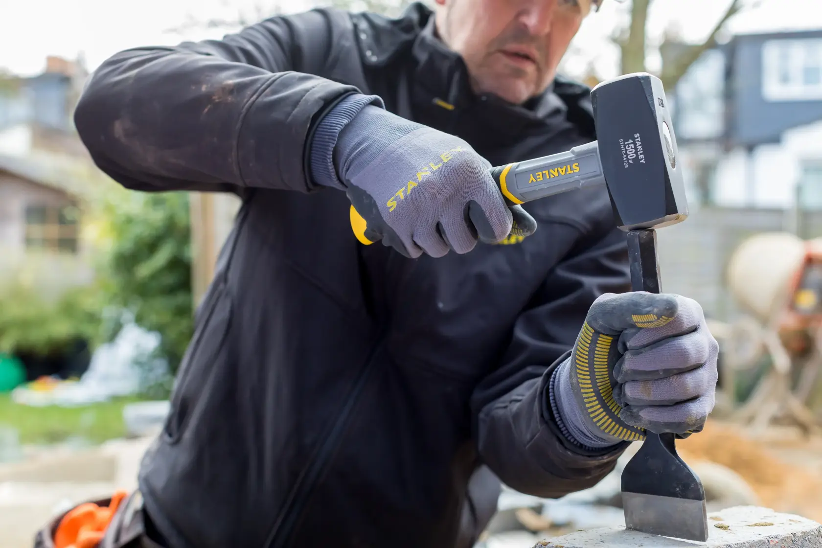 Fotografía del mazo STANLEY STHT0-54128 usado por trabajador con guantes en exterior.