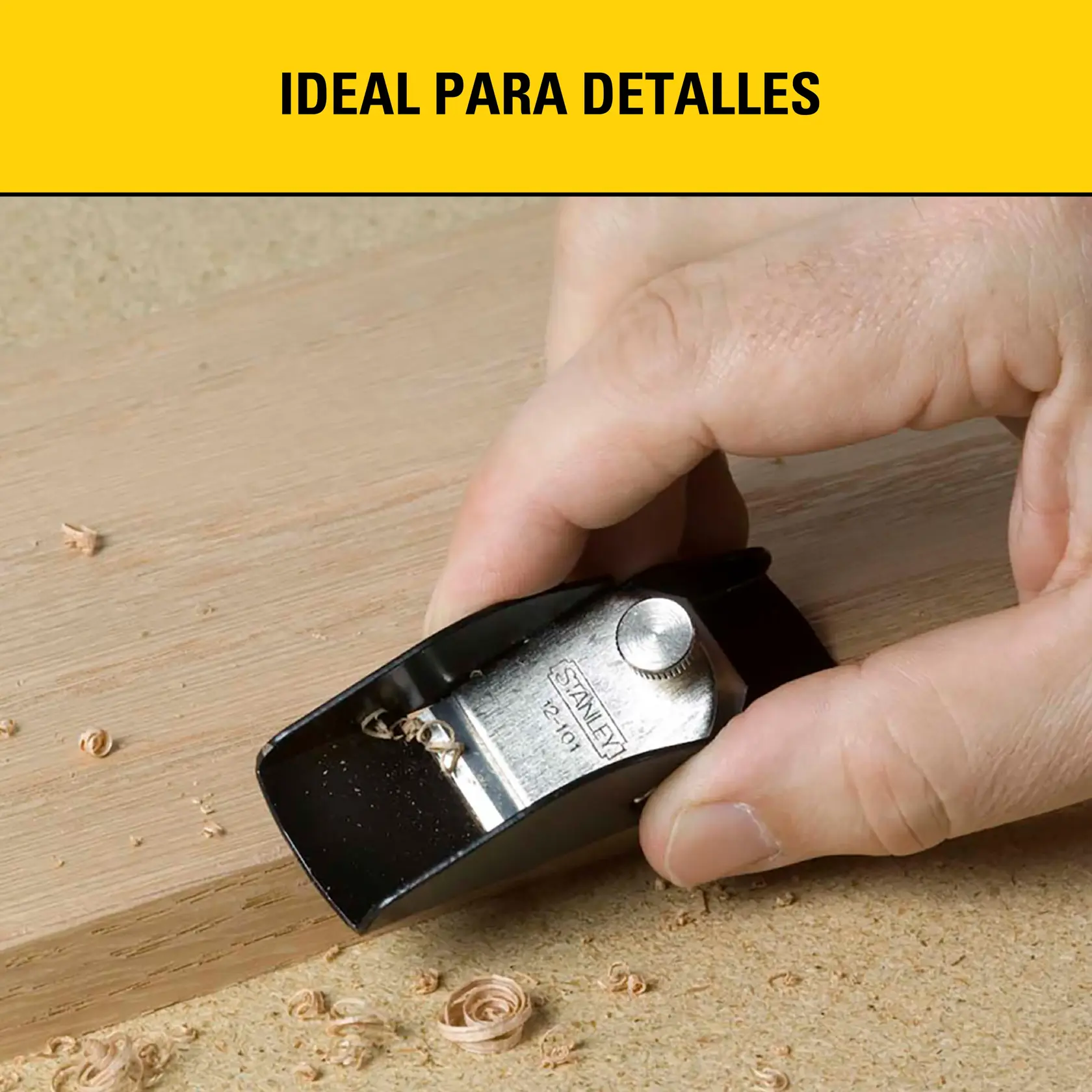 Primer plano de una mano utilizando una cepilla de bloque STANLEY 12-101 para raspar madera, con virutas visibles en la superficie. La imagen muestra la frase 'Ideal para detalles' en fondo amarillo.