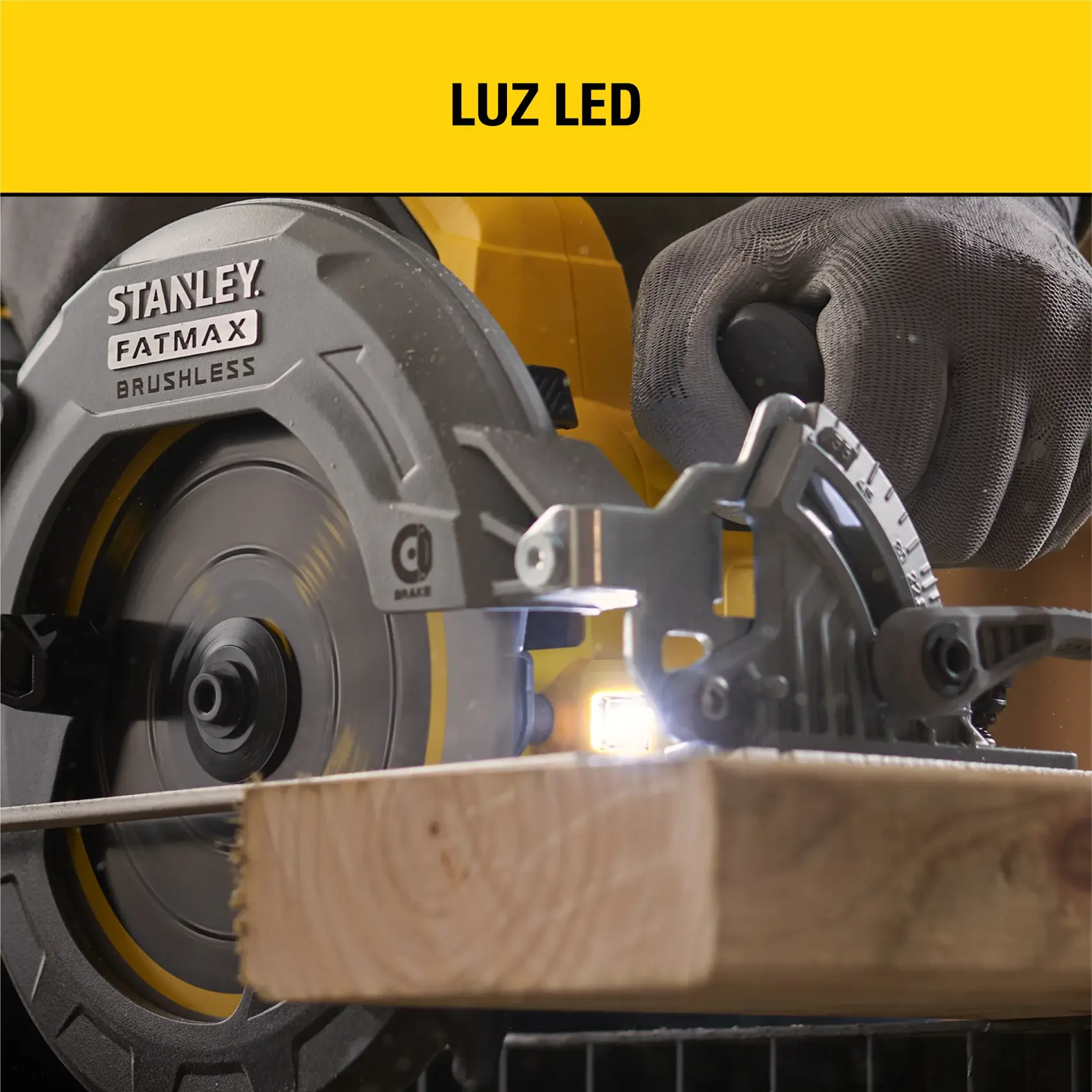 Primer plano de una sierra circular STANLEY FATMAX sin escobillas cortando una pieza de madera, con una luz LED integrada iluminando el área de corte. Una persona opera la sierra usando guantes.