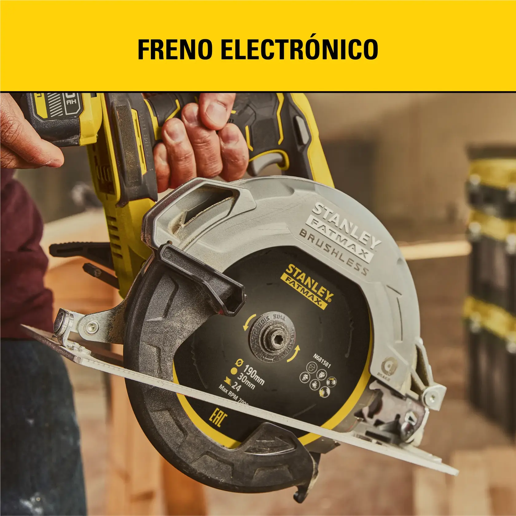 Primer plano de una persona sosteniendo una sierra circular Stanley Fatmax brushless, destacando su freno electrónico. La sierra está en un taller.