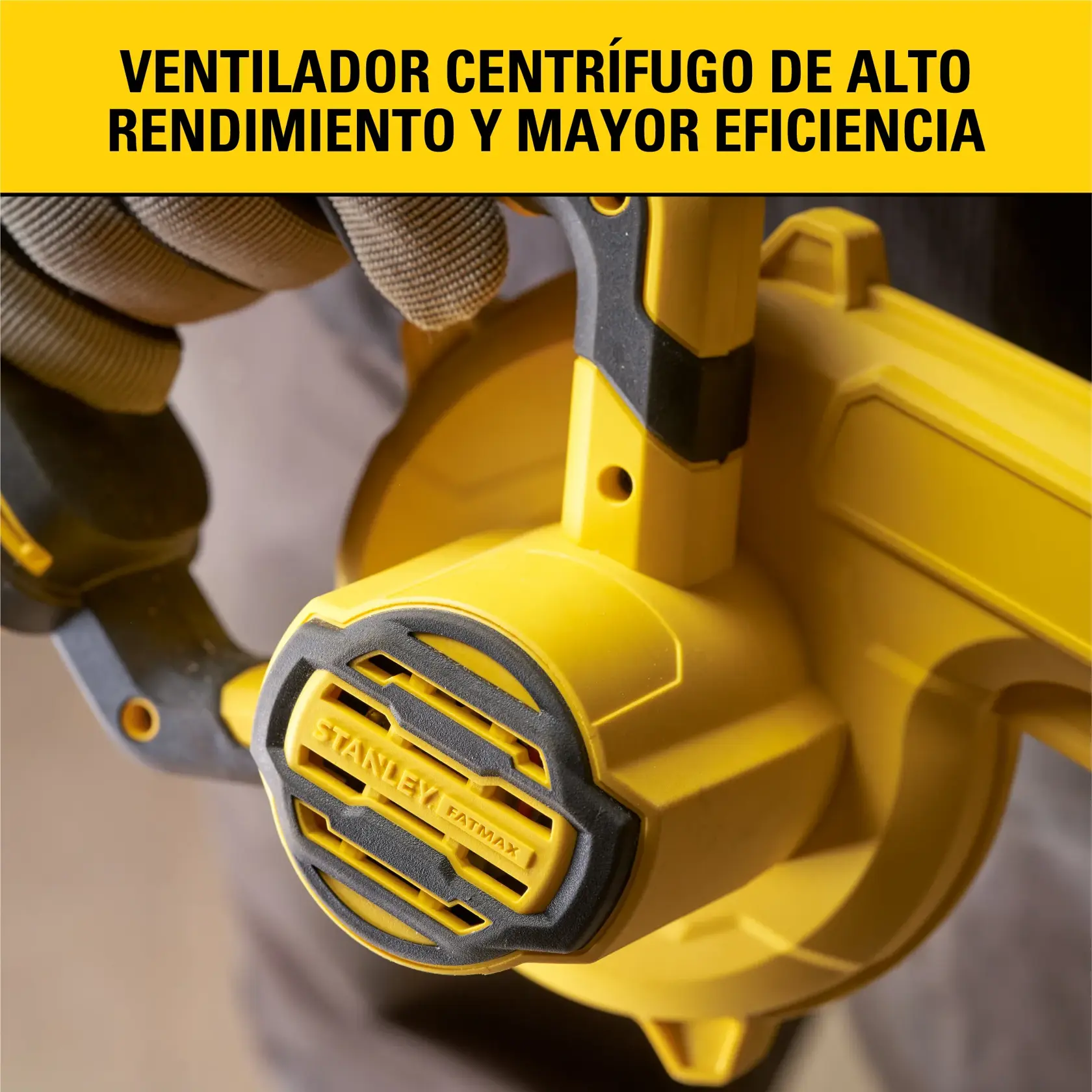 Primer plano de un ventilador centrífugo amarillo STANLEY Fatmax sostenido por una persona que lleva guantes, destacando su alto rendimiento y eficiencia. Información del producto en español en la parte superior.
