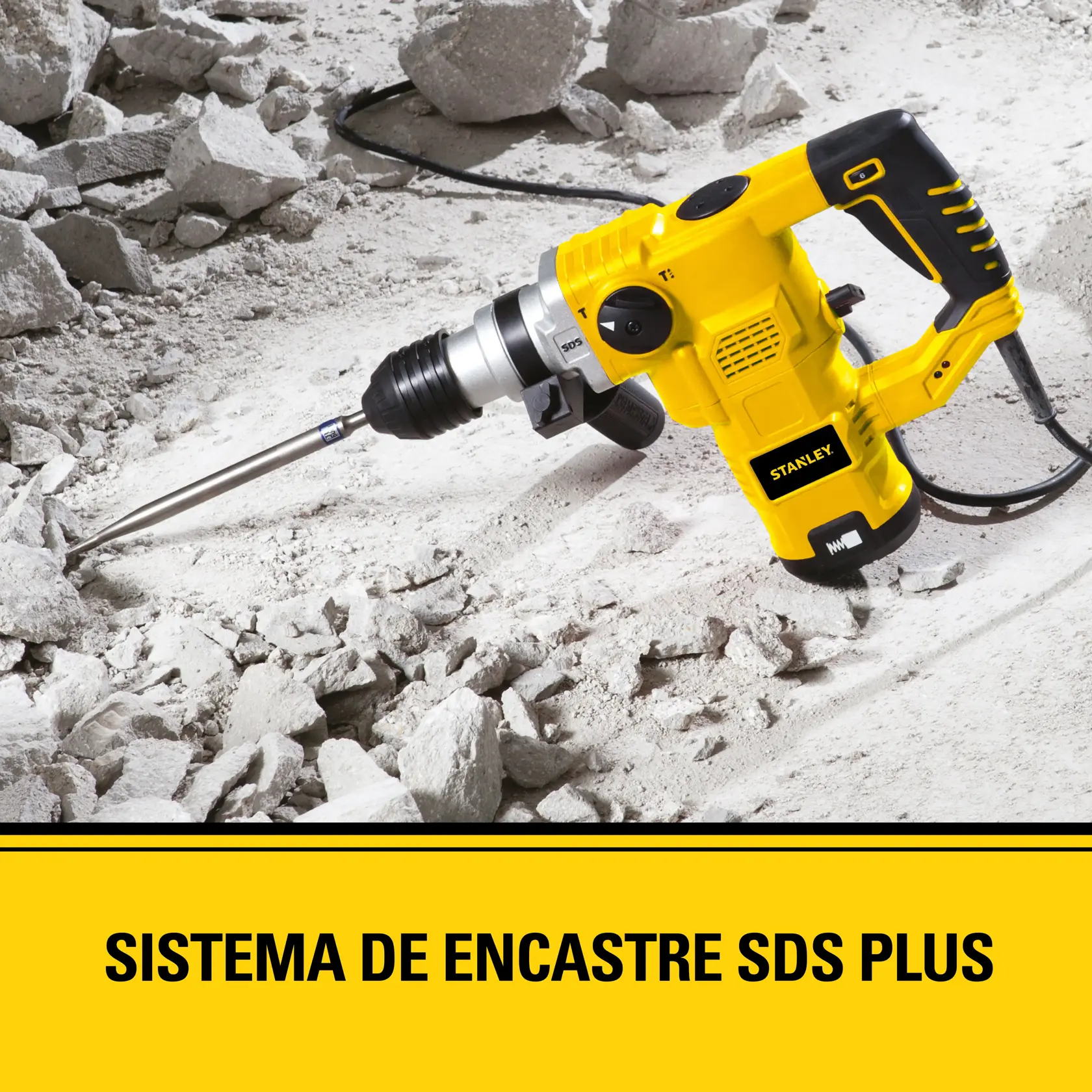 Un taladro rotativo Stanley SDS Plus amarillo rompiendo escombros de concreto. La herramienta está siendo utilizada entre restos dispersos. El texto en la parte inferior dice: 'SISTEMA DE ENCASTRE SDS PLUS'.