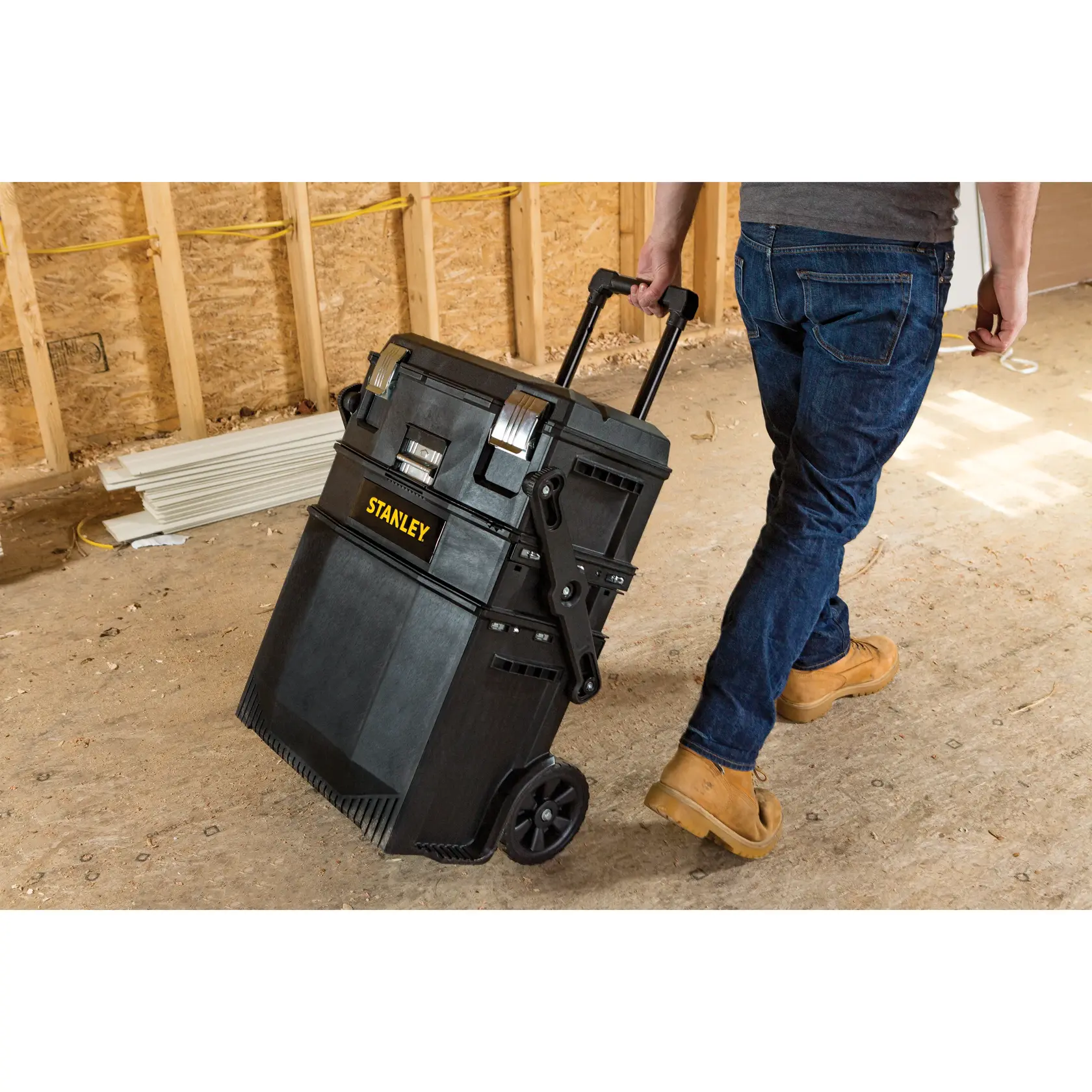 STANLEY SKU 020800R caja de herramientas rodante negra con asa en obra de construcción, vista lateral.