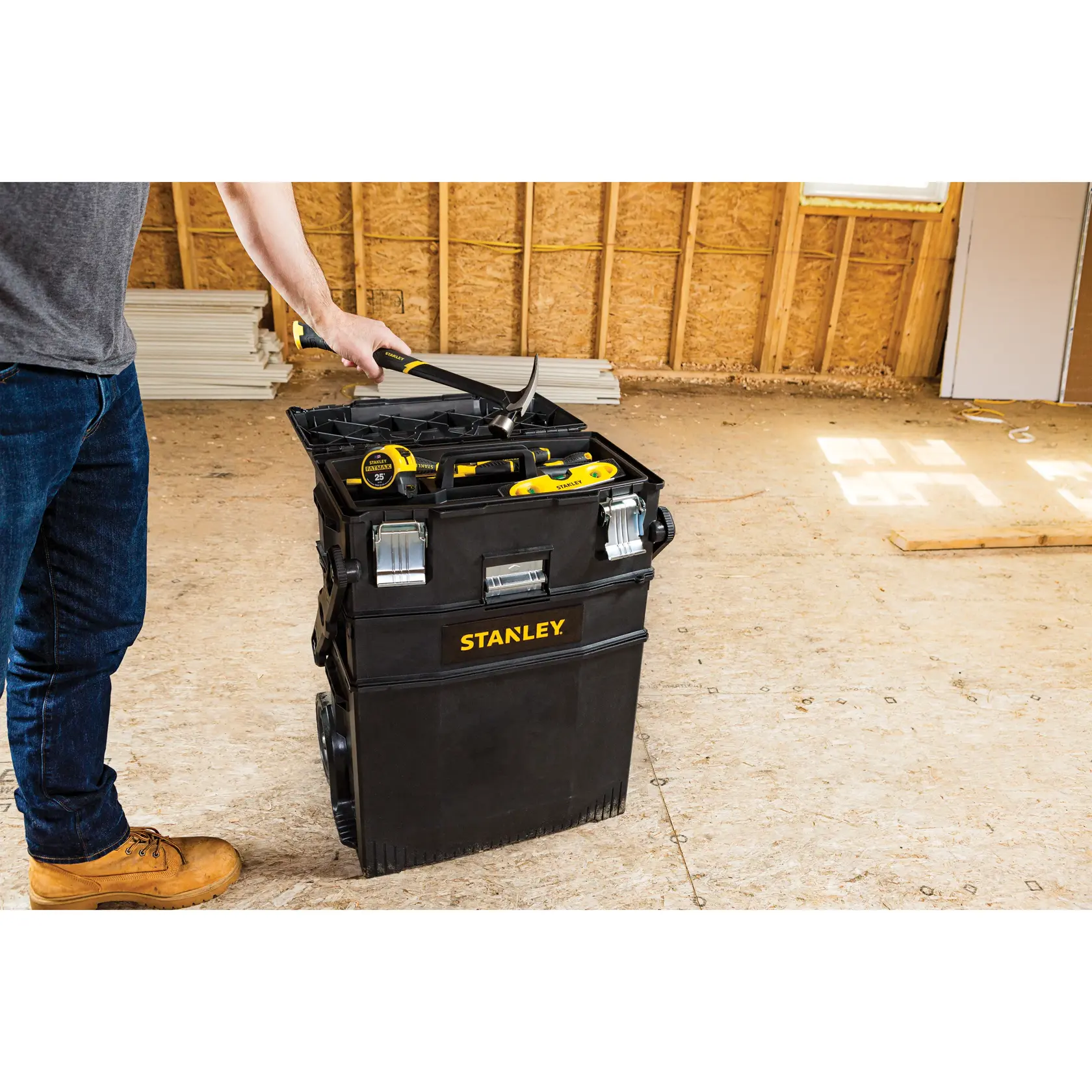 Stanley 020800R baúl de herramientas rodante negro con herramientas, entorno de construcción interior, vista lateral.