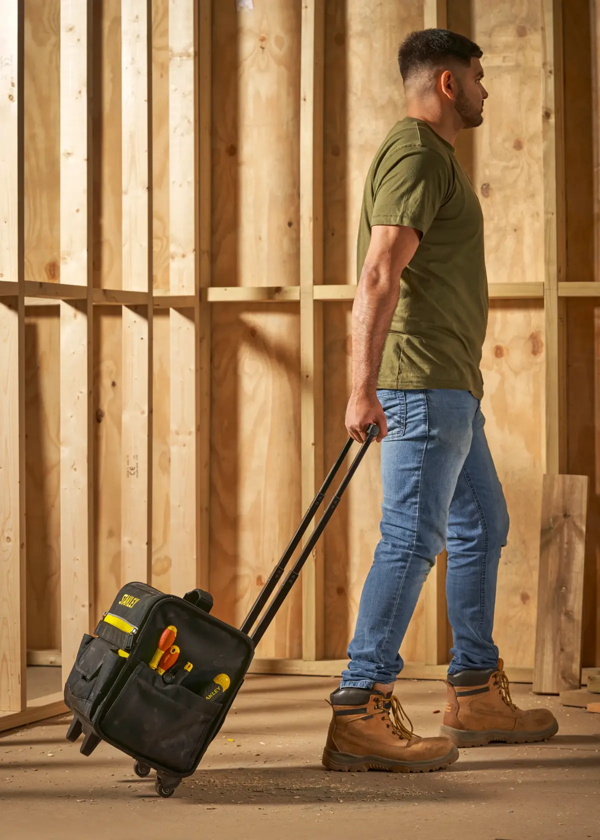 STANLEY 1-97-515 bolsa de herramientas con ruedas y herramientas, llevada por persona en obra.