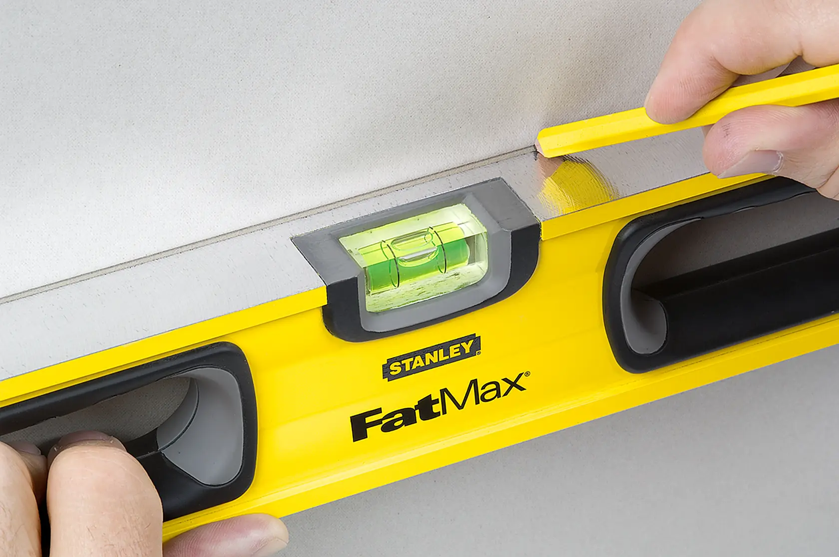Stanley 43-524 FatMax nivel usado para trazar una línea recta en una pared, fotografía en primer plano.