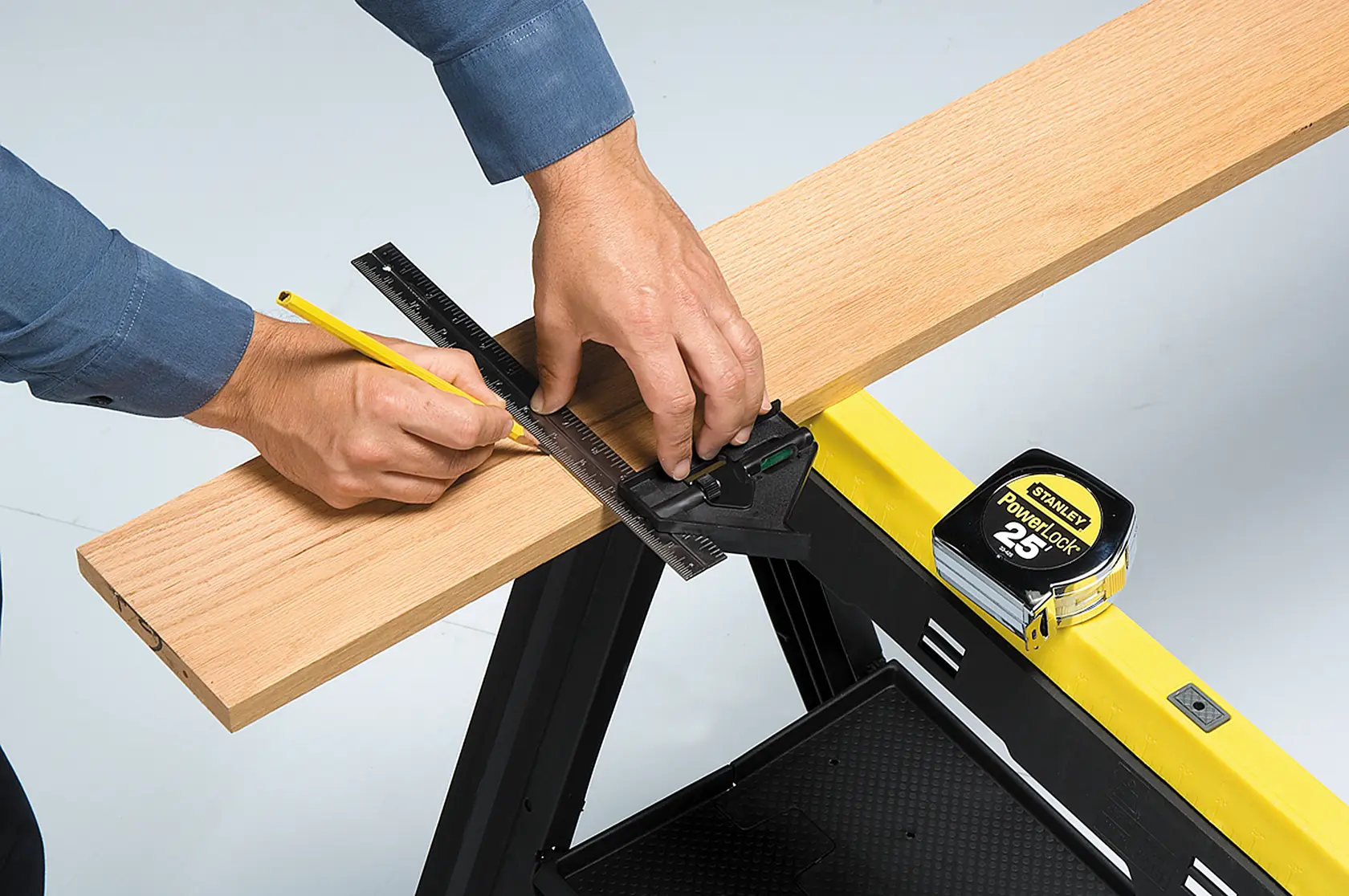 Fotografía de STANLEY 46-012, escuadra combinada utilizada para marcar madera, cinta métrica sobre caballete amarillo.