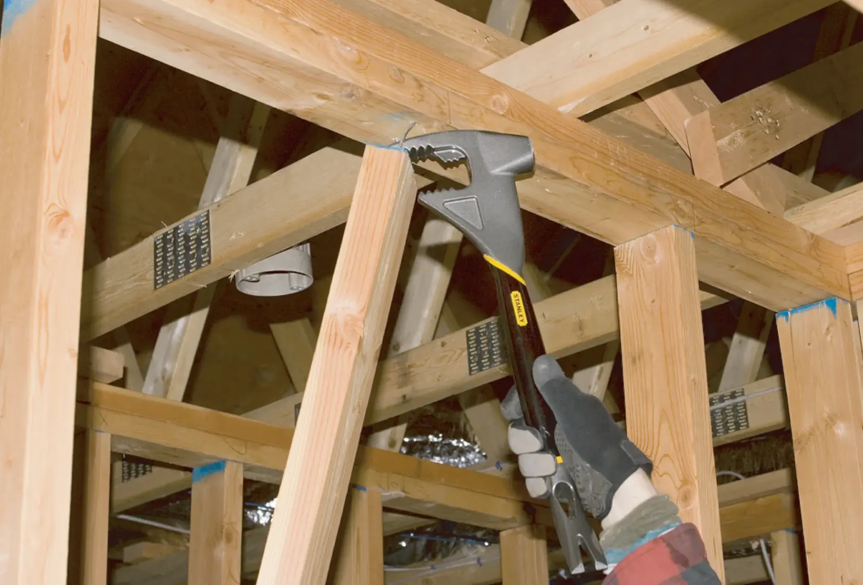 Stanley 55-099 herramienta de barra de uña usada en estructura de madera, foto en construcción.