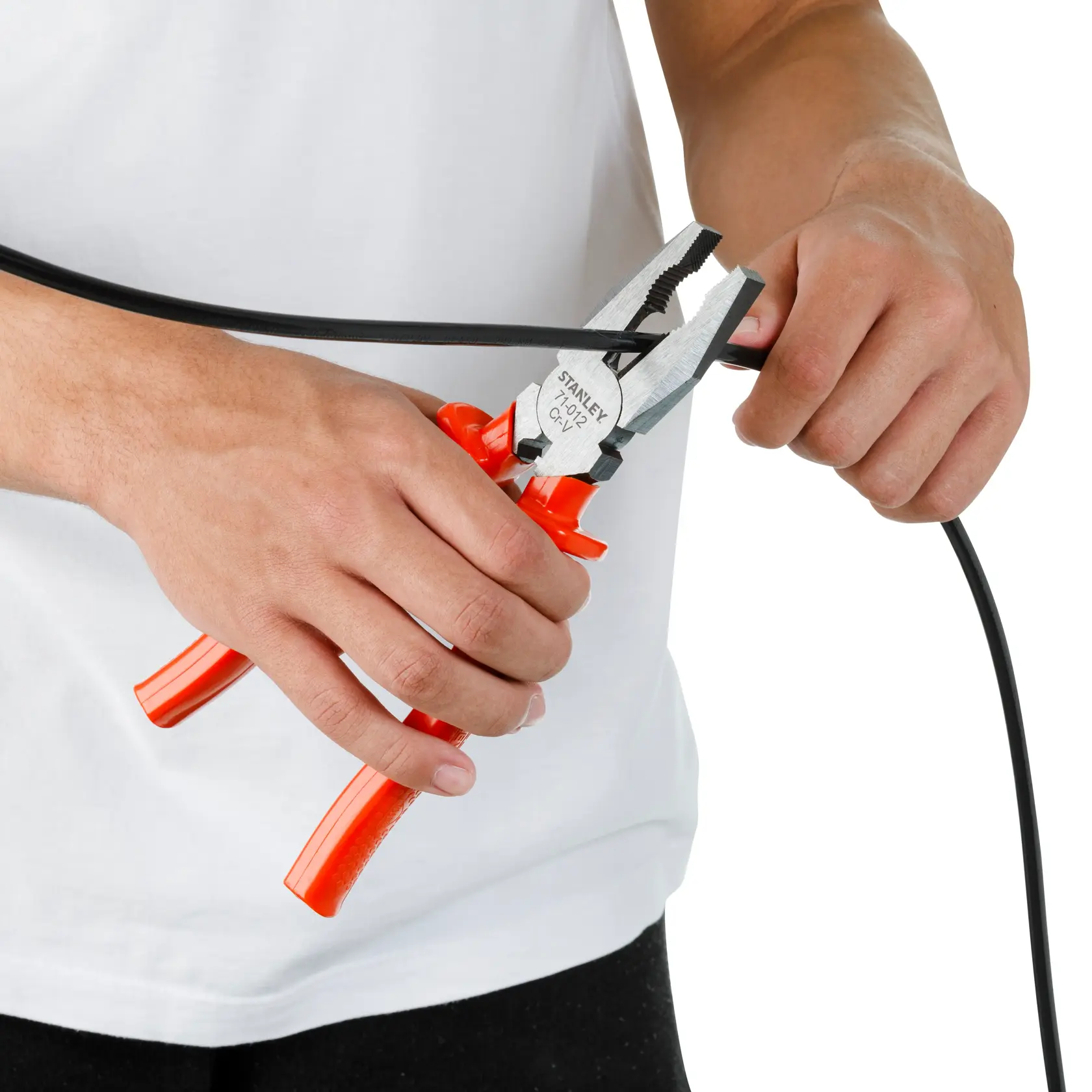 Fotografía de pinzas STANLEY 71-012 con mangos naranjas cortando un cable negro, sostenidas por persona en camiseta blanca.