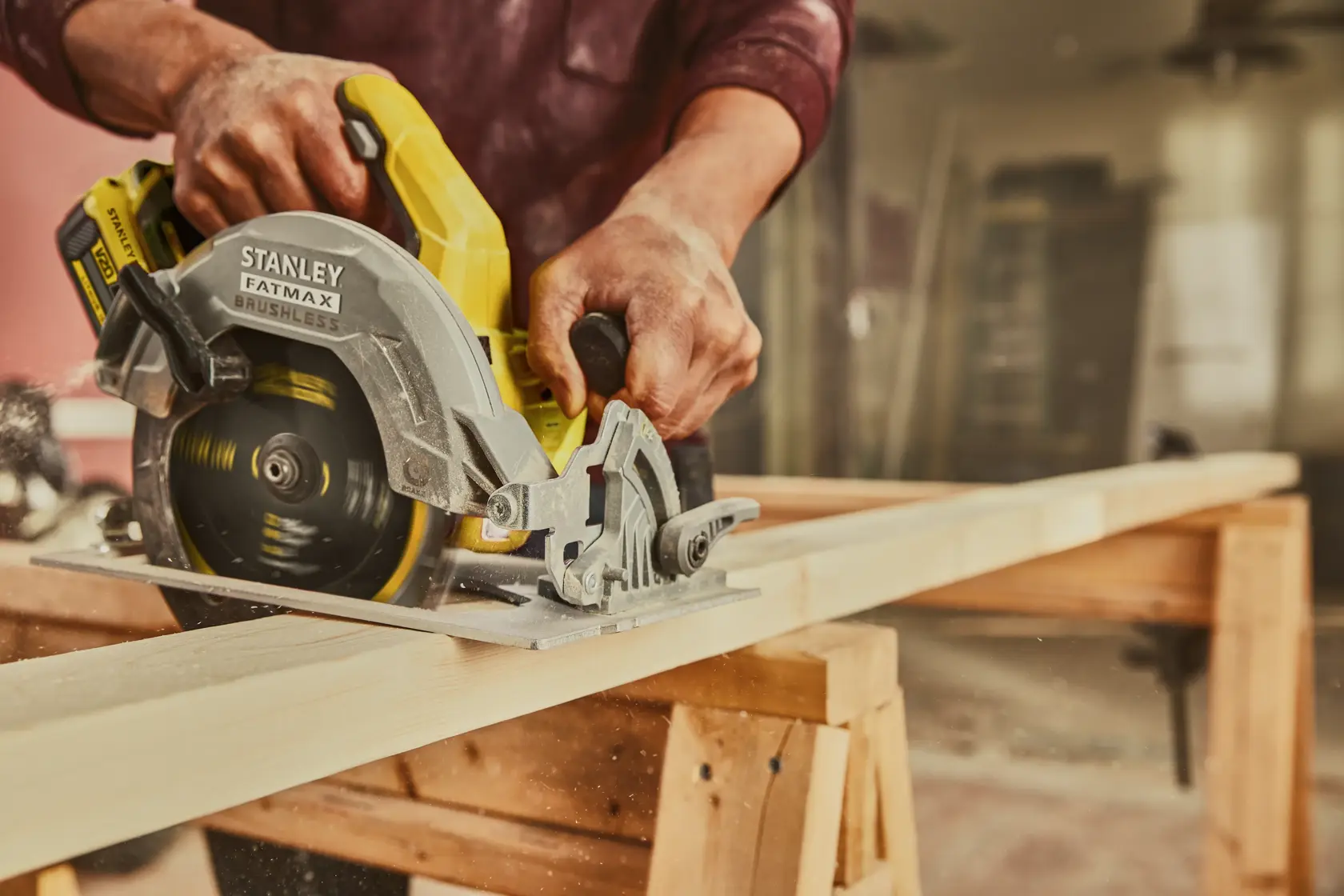 Sierra circular STANLEY SBC550D2K-B3 cortando madera en un banco de trabajo, vista cercana con marca y disco visibles en uso.
