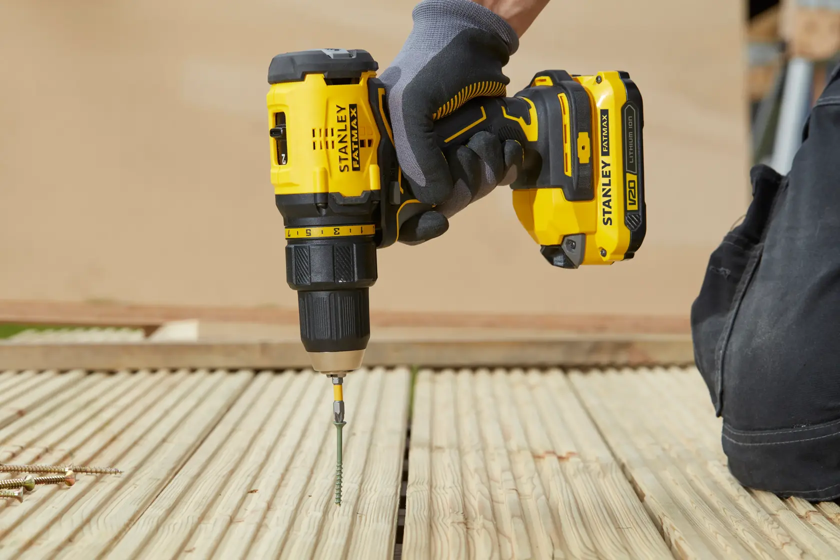 Fotografía del taladro inalámbrico STANLEY SBD710C2K-BR en uso sobre superficie de madera.