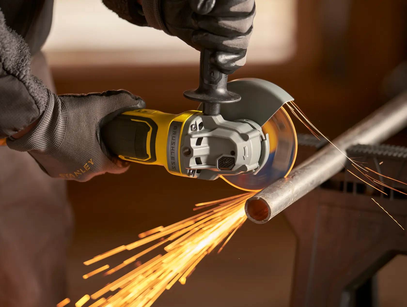 Stanley SBG700 amoladora angular cortando tubo de metal con chispas, primer plano, fotografía de producto.