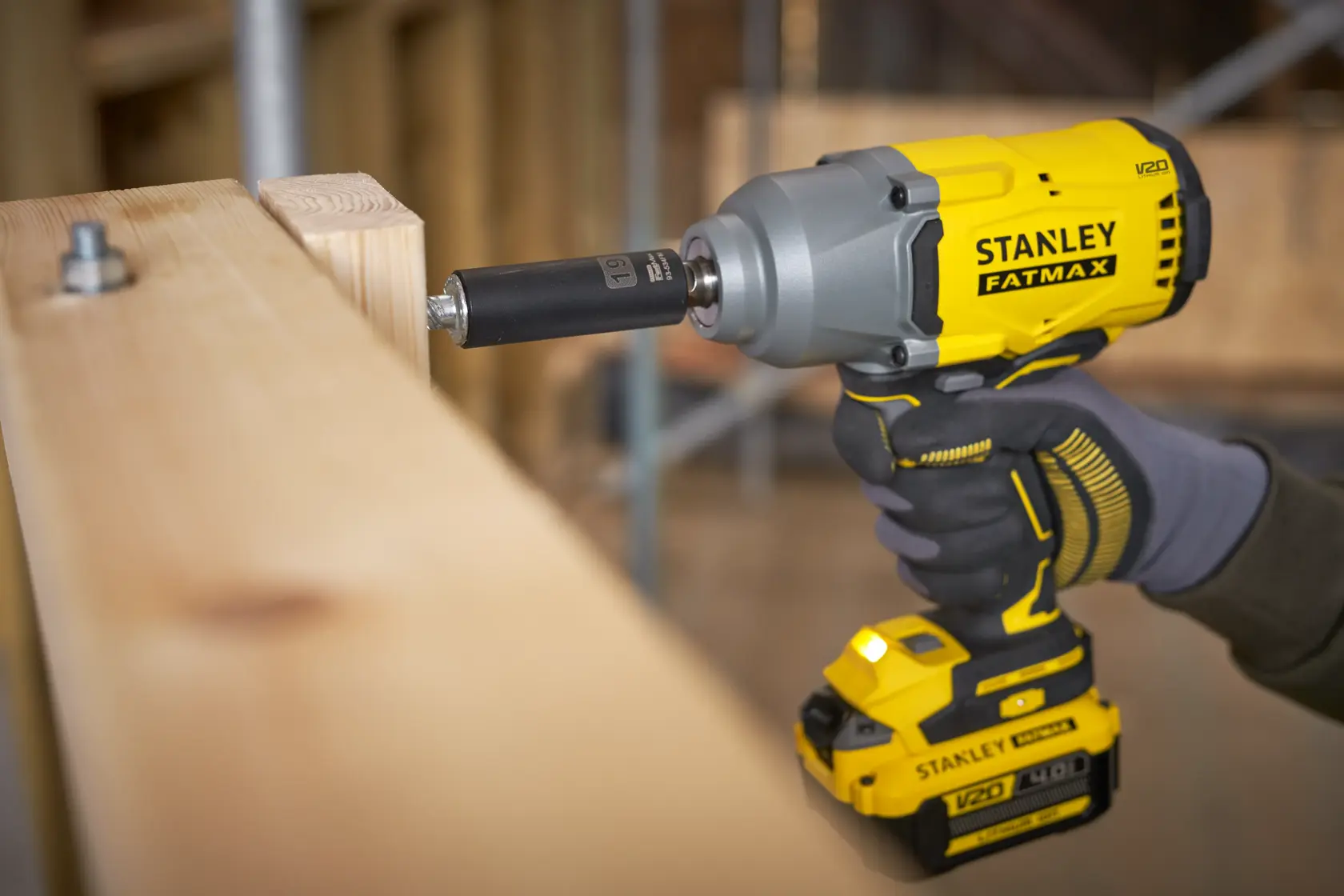Fotografía de la llave de impacto inalámbrica STANLEY SBW940 utilizada para atornillar un perno en vigas de madera, vista en primer plano.