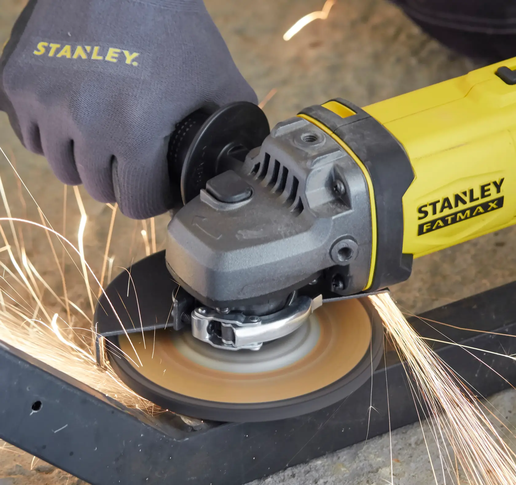 STANLEY SCG400 amoladora angular cortando metal con guante de seguridad, fotografía de lado.