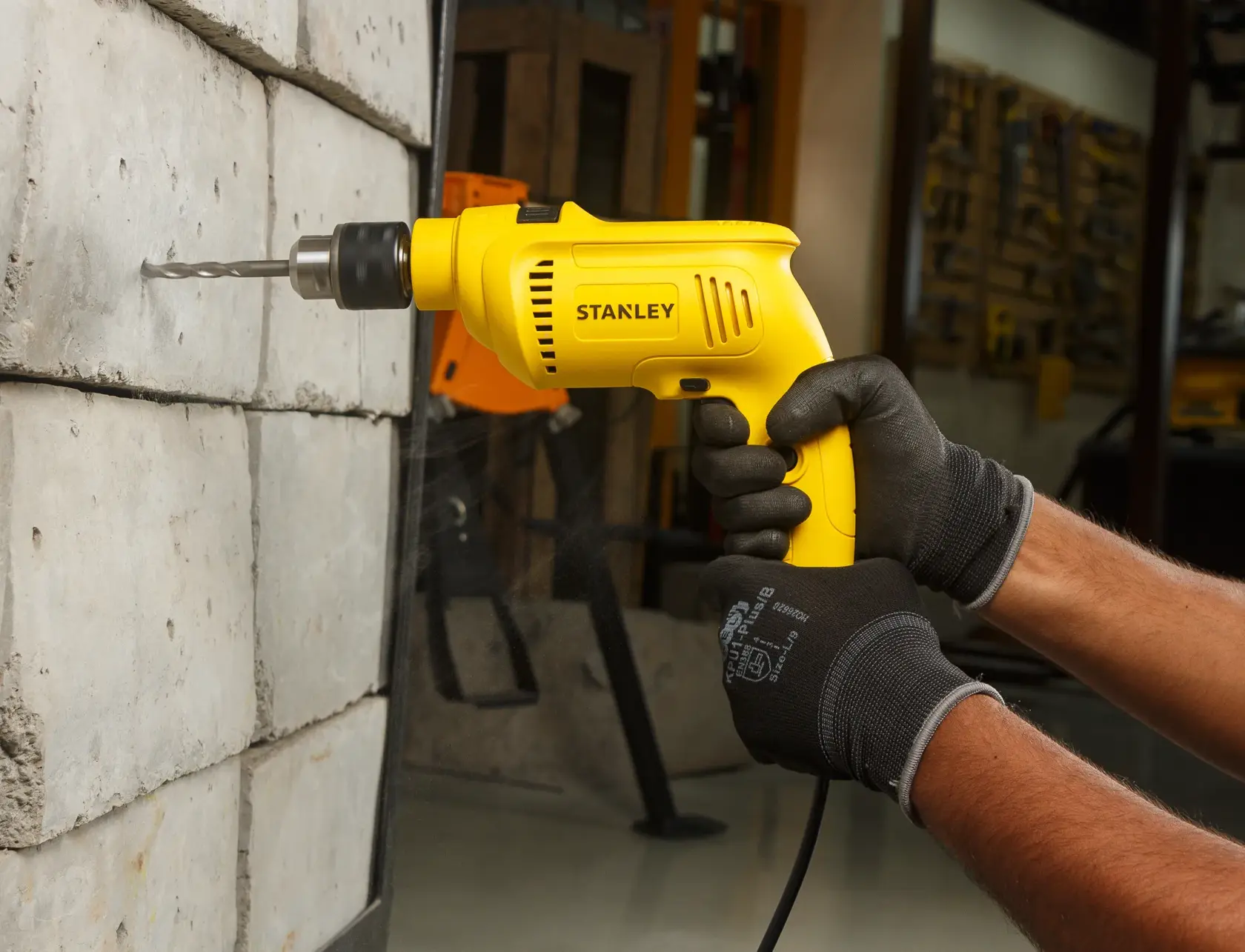 Stanley SDH600KP taladro amarillo con cable en uso, perforando una tabla de madera en taller, vista cercana.