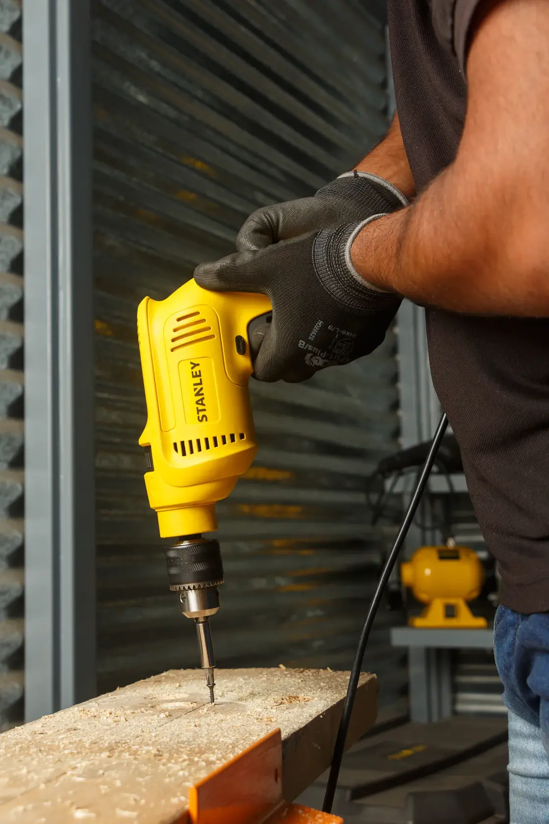 Stanley SDH600KP taladro con cable en uso perforando madera, toma de lado, categoría fotografía.