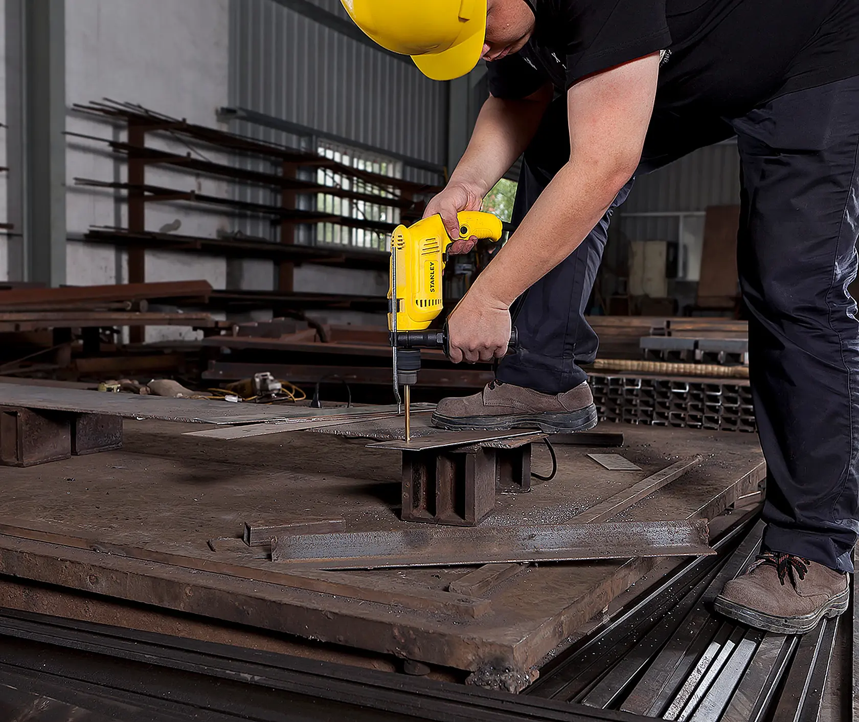 STANLEY SDH600 taladro amarillo usado para perforar lámina de metal en taller industrial, vista lateral.