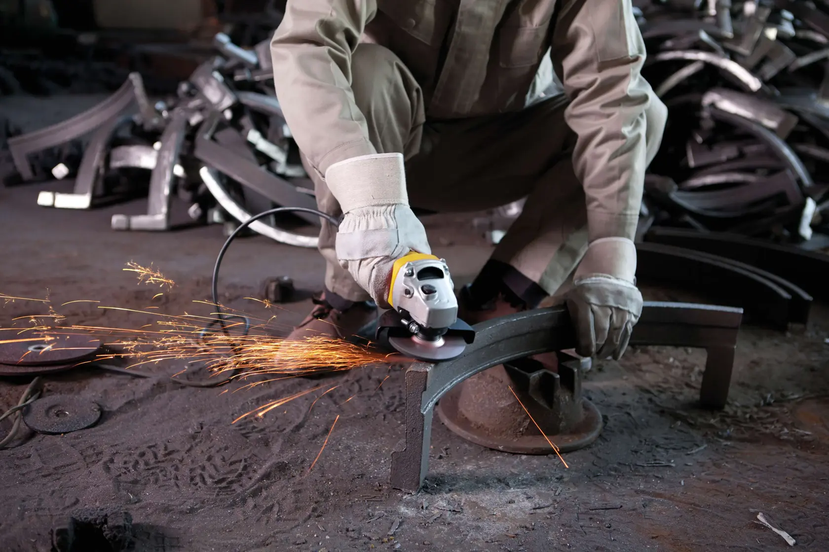 Amoladora angular STANLEY SGS1045K en uso, trabajador cortando metal con chispas, entorno industrial.