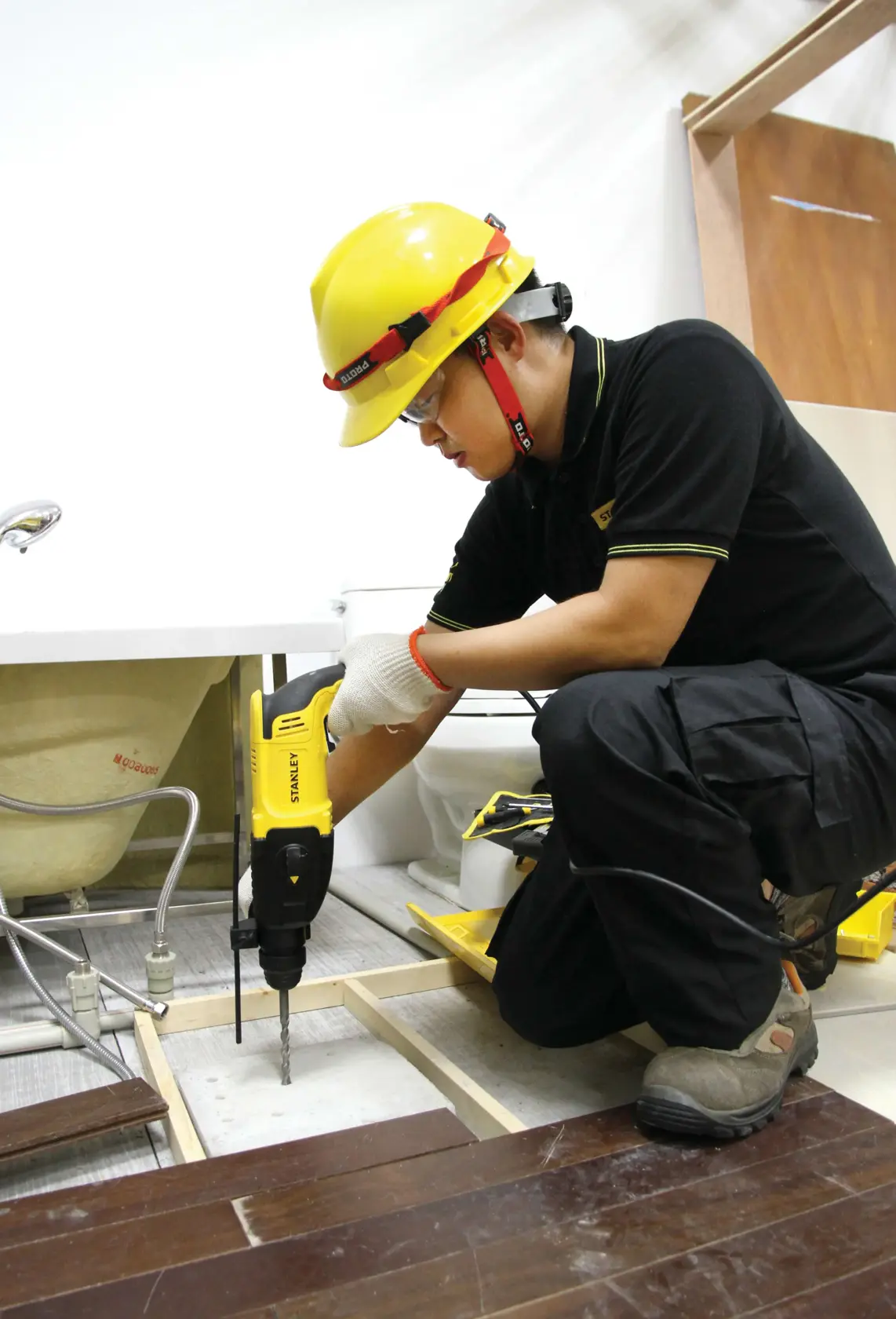 Martillo rotatorio Stanley SHR263K-BR en uso durante instalación de piso, trabajador con equipo de seguridad.