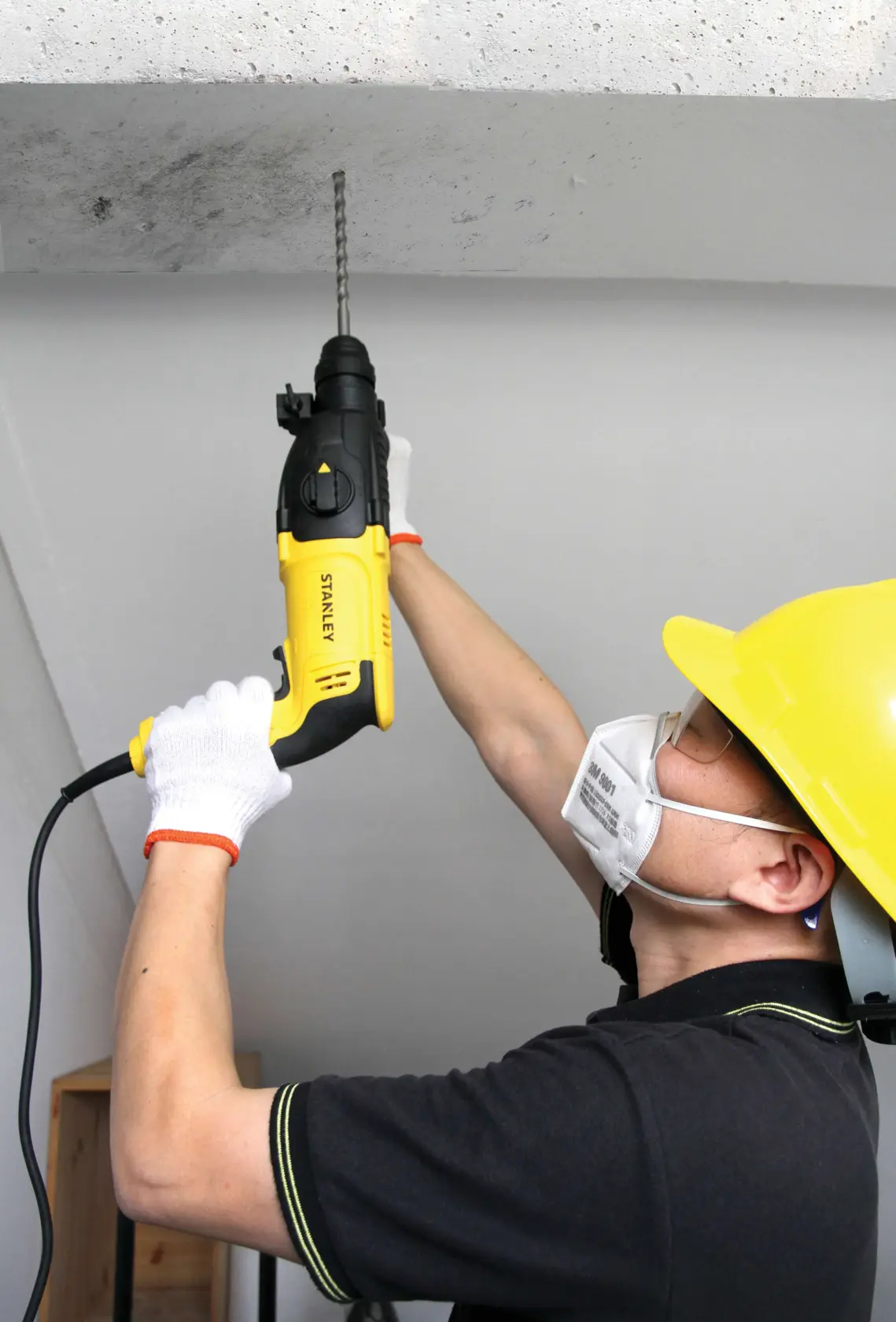 Stanley SHR263K-BR taladro rotatorio en uso, amarillo y negro, perforando techo de concreto.