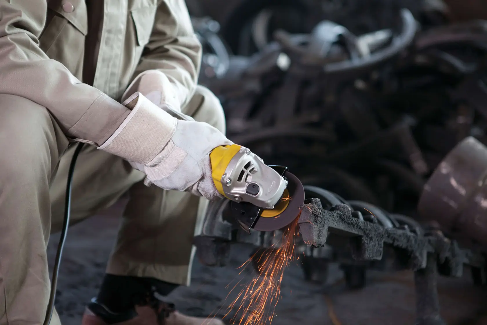 Amoladora angular STANLEY STGS8115 en uso, trabajador cortando metal con chispas, vista en primer plano.