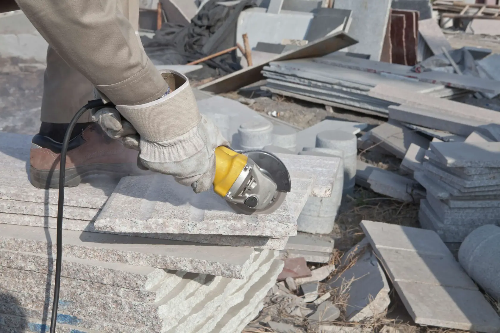 STANLEY STGS8115 amoladora angular cortando placas de piedra, primer plano en construcción exterior.