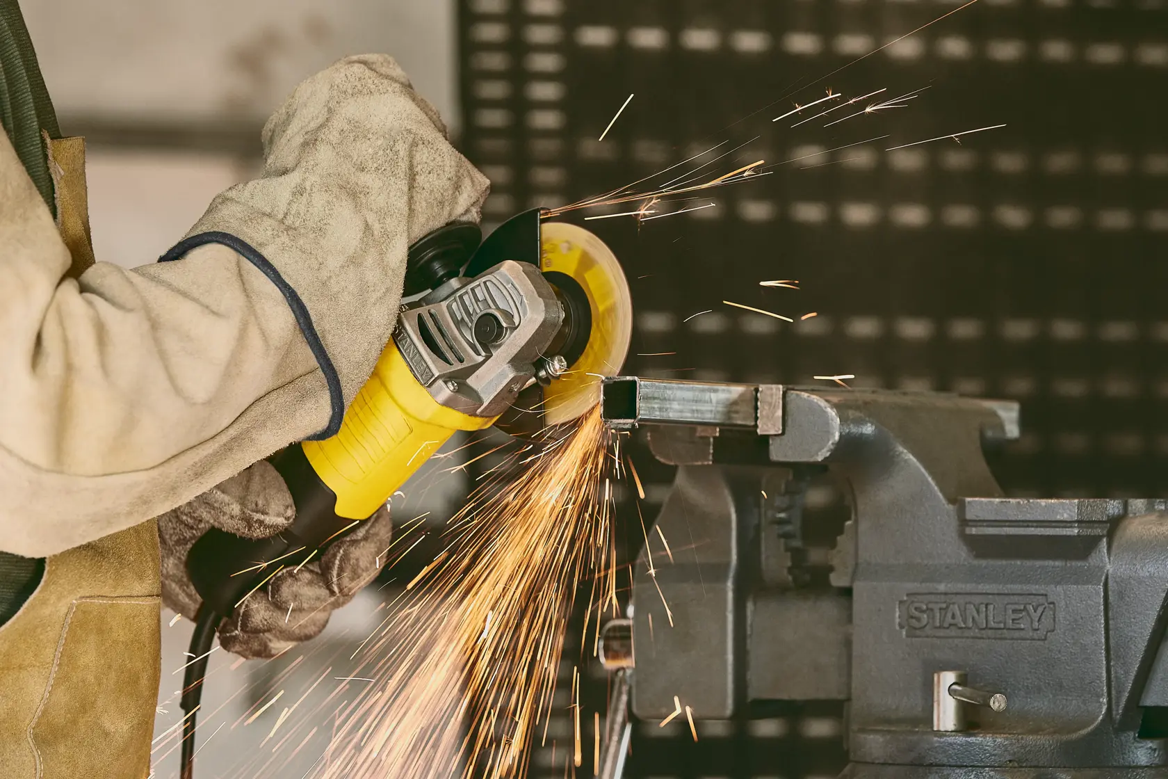 Stanley stgs9115 amoladora angular en uso, chispas al cortar metal, fotografía en primer plano.