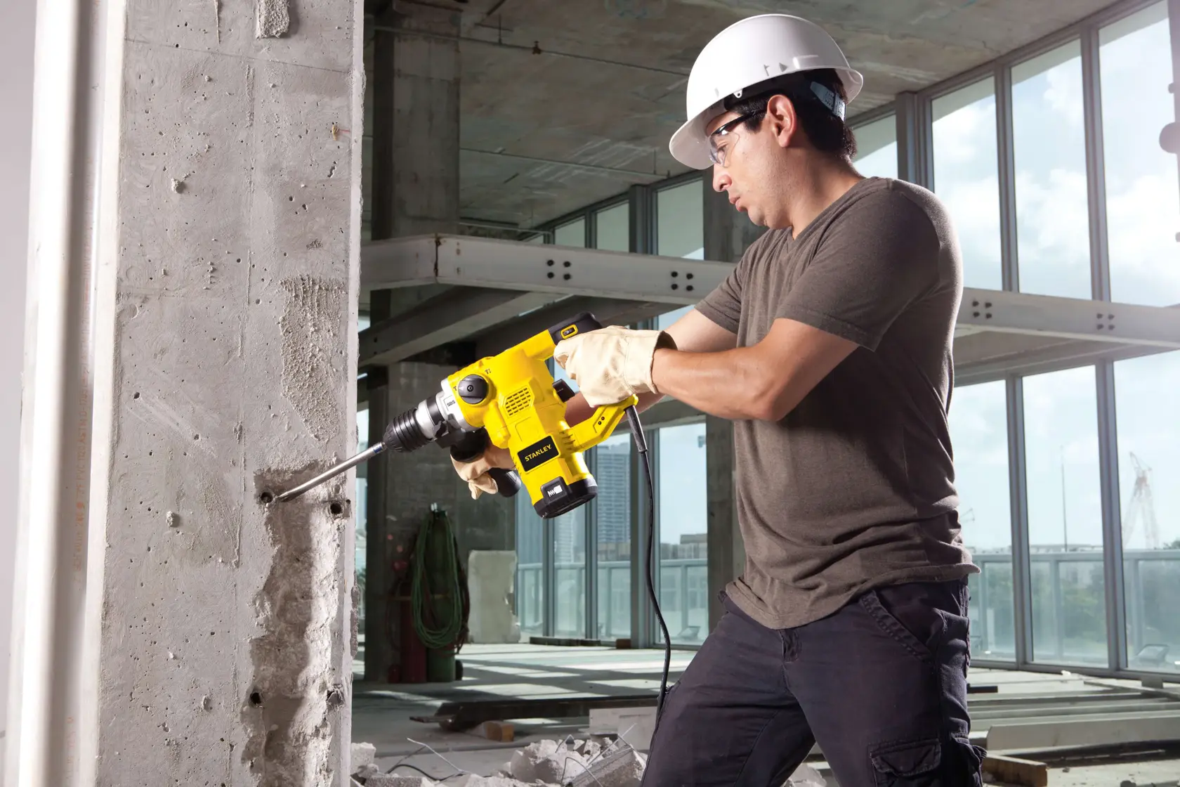 Martillo rotativo STANLEY STHR1232K utilizado para perforar una pared de concreto en un sitio de construcción.