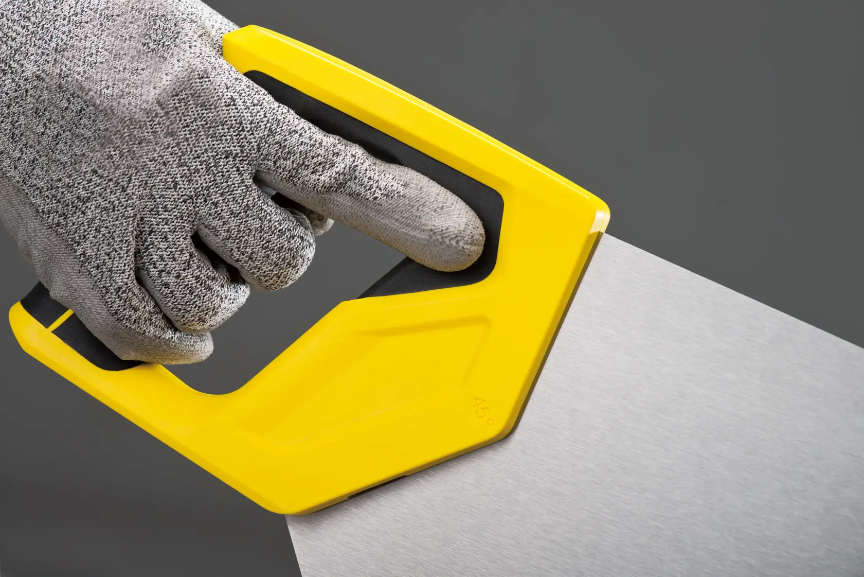 Fotografía de serrucho STANLEY STHT20375-LA con mango amarillo cortando madera, utilizado por persona con guantes.