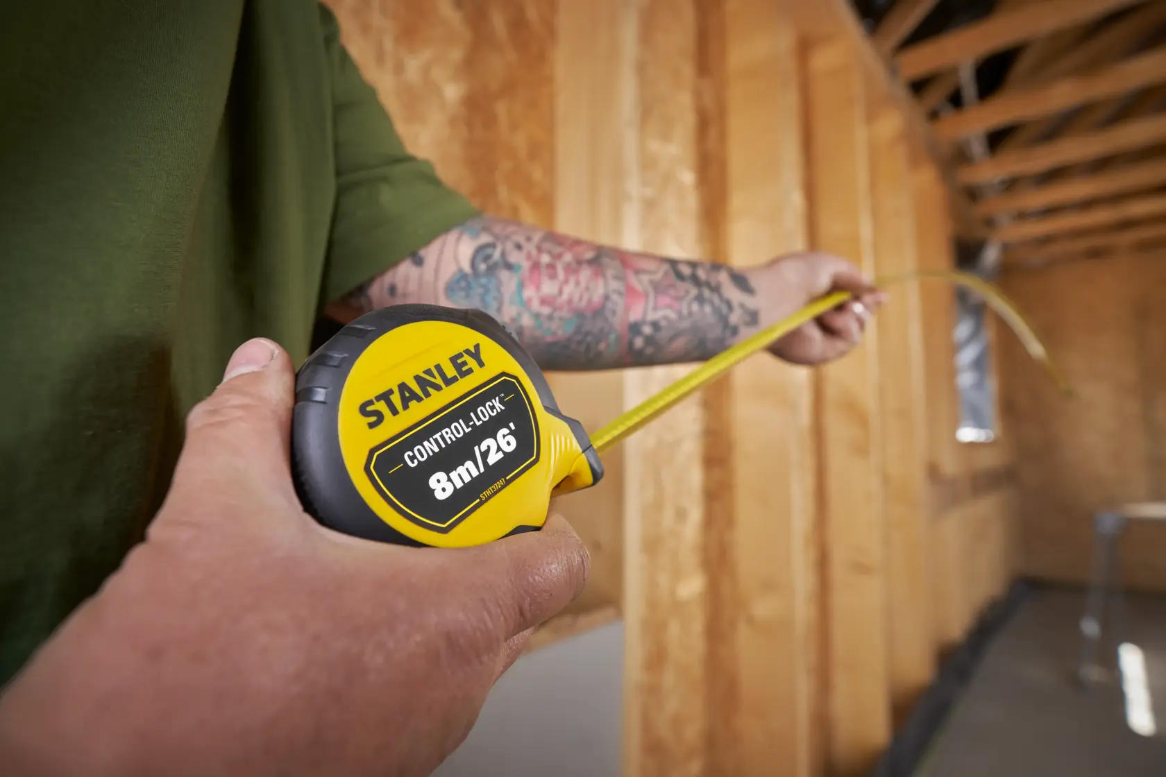 Fotografía de la cinta métrica STANLEY STHT37247-0 en uso dentro de un sitio de construcción.