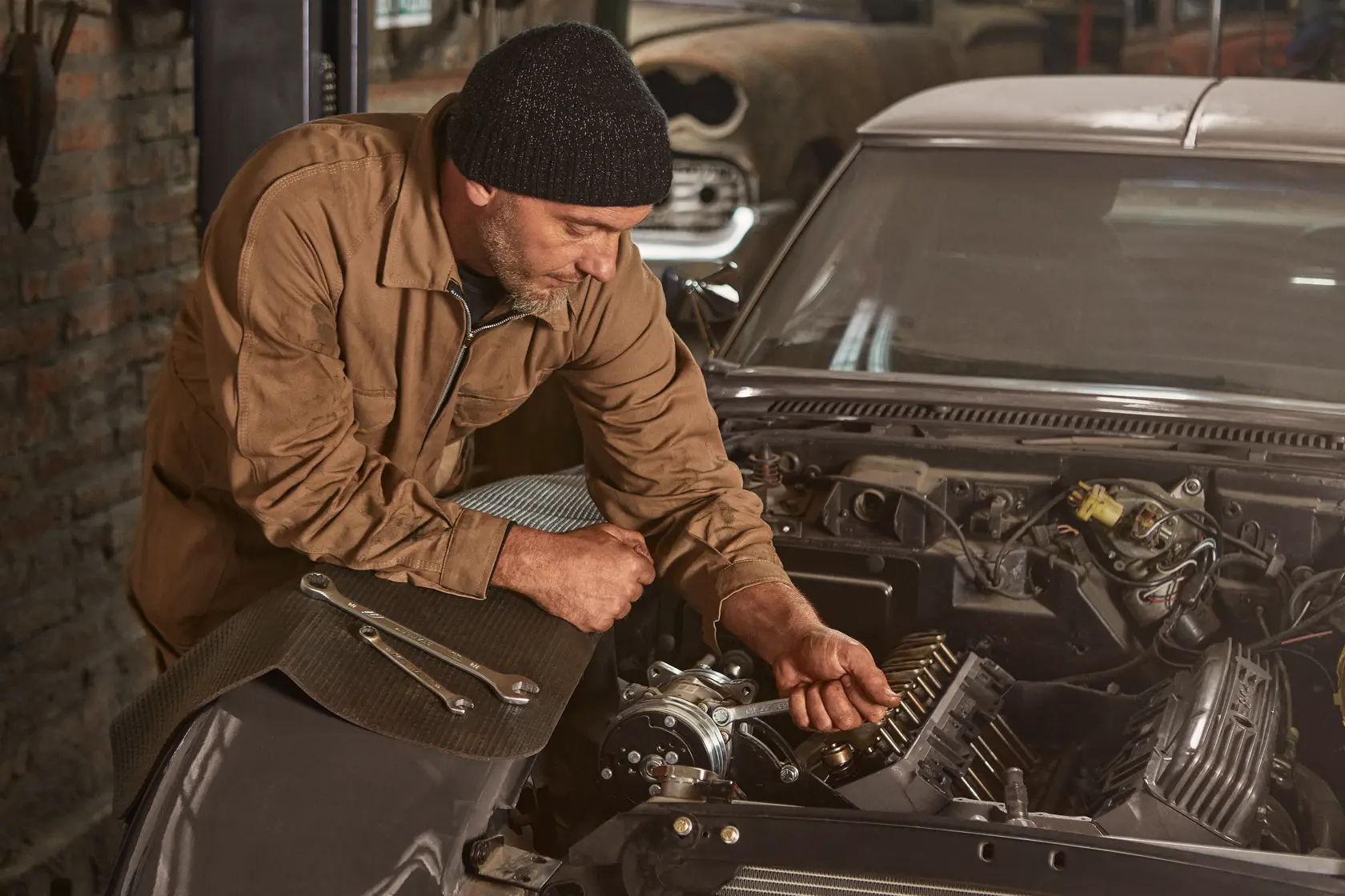STANLEY STMT72834 llaves sobre el capó de un auto, mecánico trabajando en el motor, entorno de taller, fotografía angular