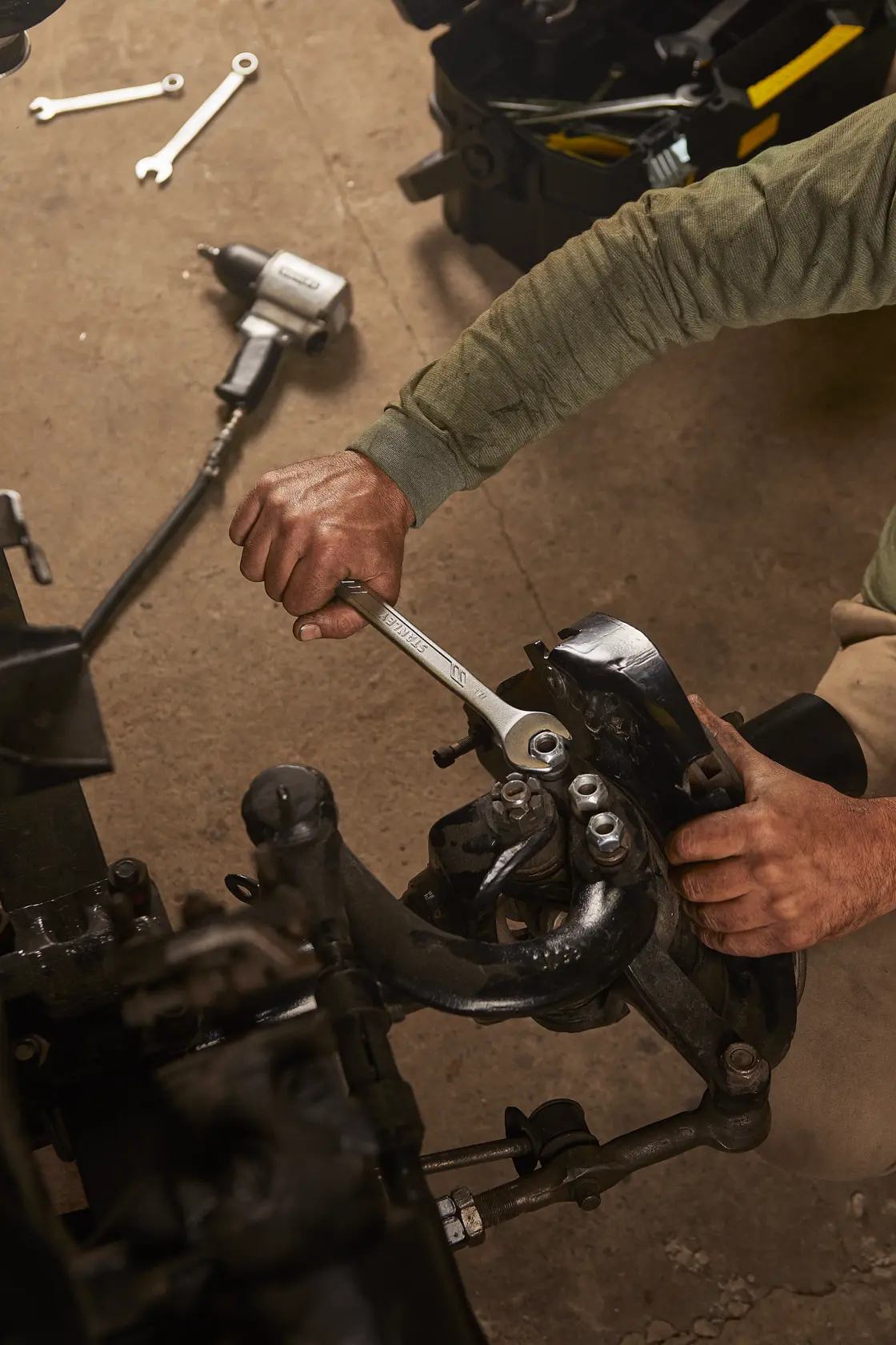 Llave STANLEY STMT72839 usada en pieza automotriz, foto de mano sujetando herramienta en taller.