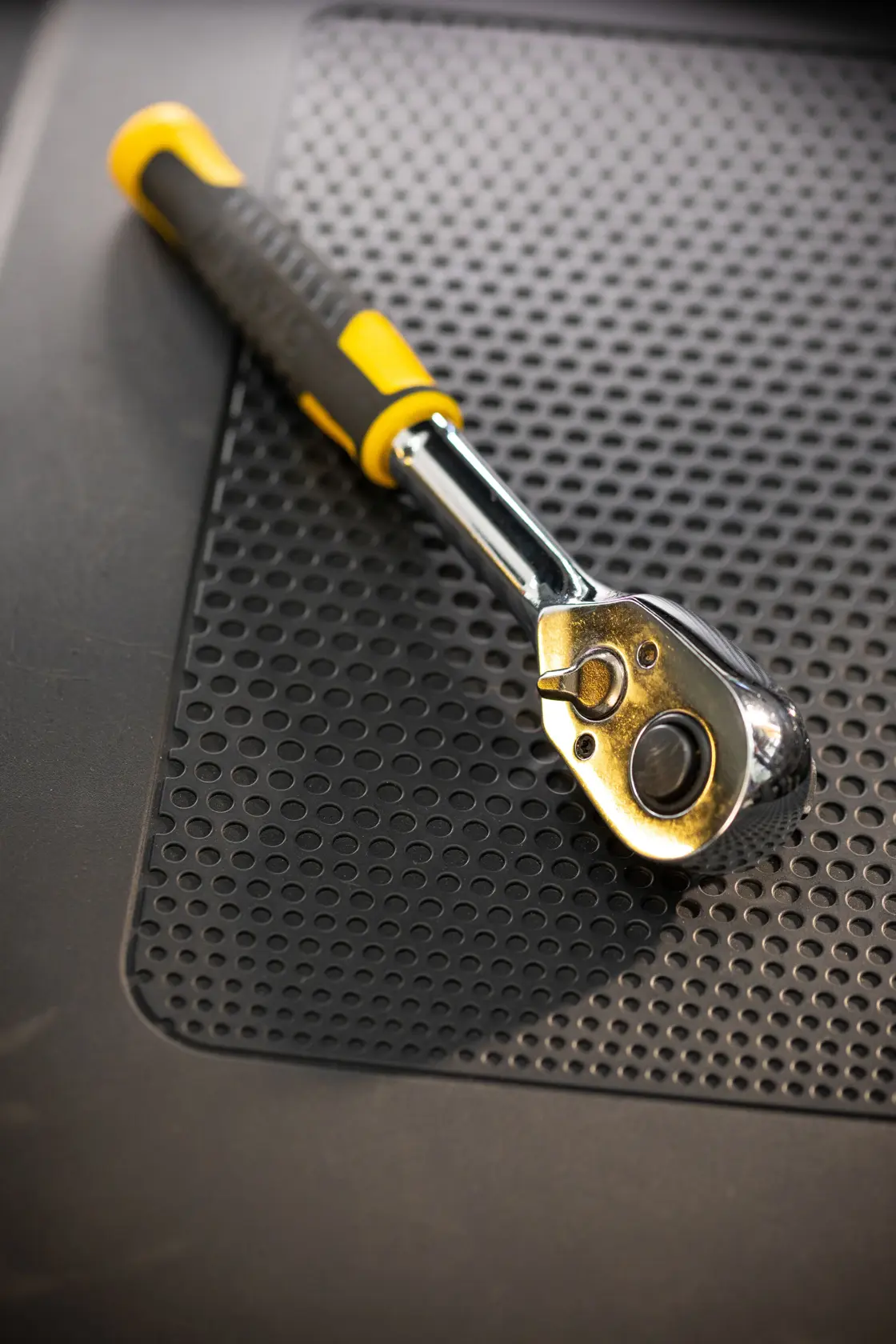 Fotografía de la llave de carraca STANLEY STMT82665-0 con mango amarillo y negro sobre alfombrilla perforada.
