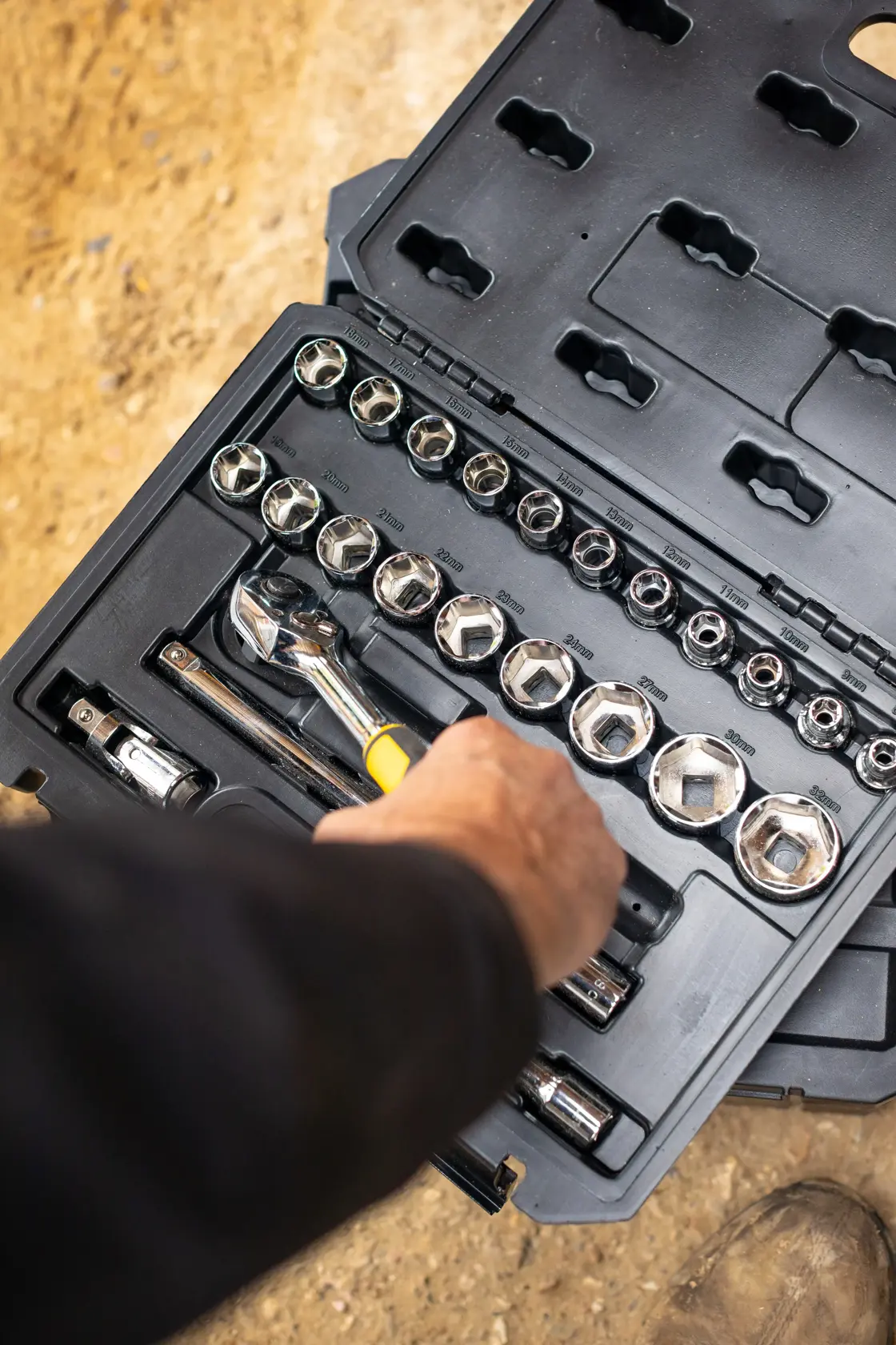 STANLEY STMT82830-LA juego de dados en estuche negro, mano sosteniendo trinquete, vista superior, fotografía de kit.