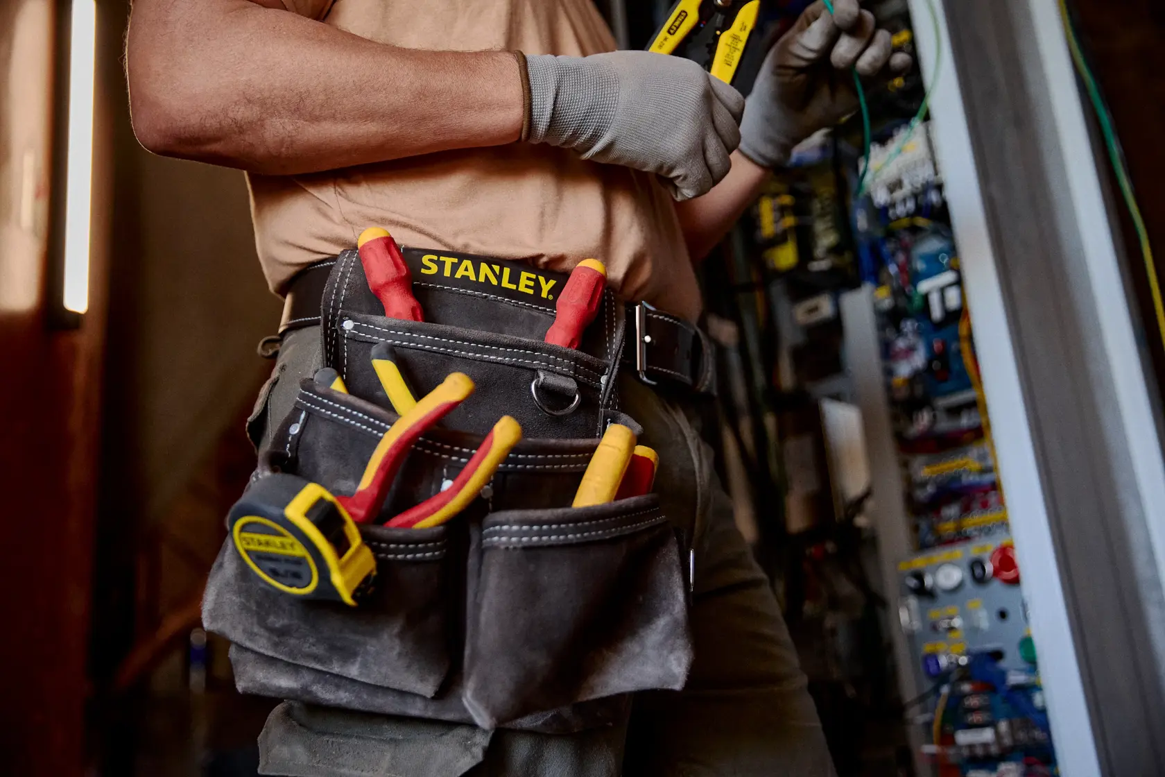 STANLEY STST1-80116 bolsa portaherramientas con herramientas de mano, cinta métrica y alicates en uso en obra.