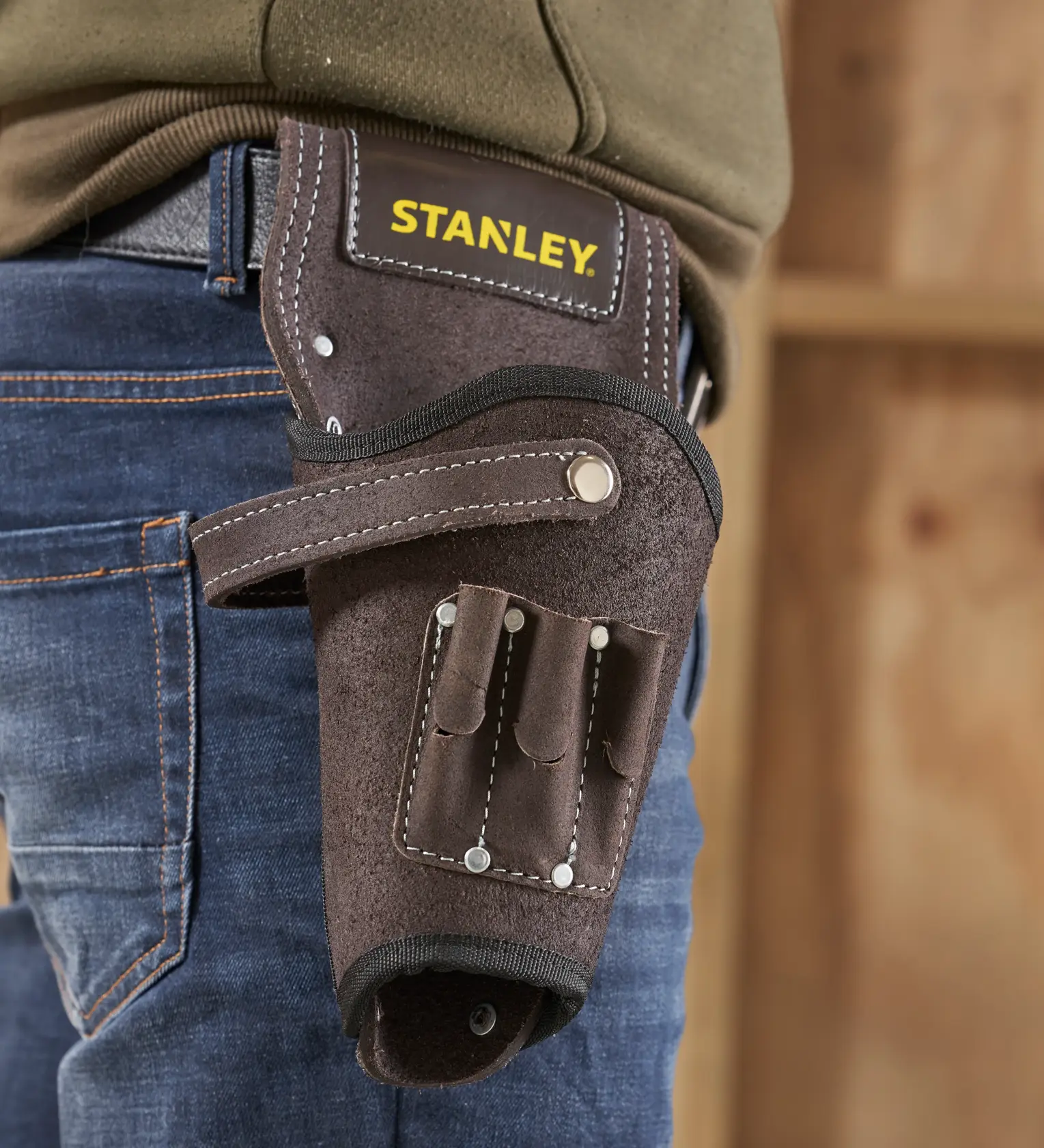 STANLEY STST1-80118 funda para herramientas de cuero marrón con varios compartimentos, en el cinturón, vista lateral de cerca.