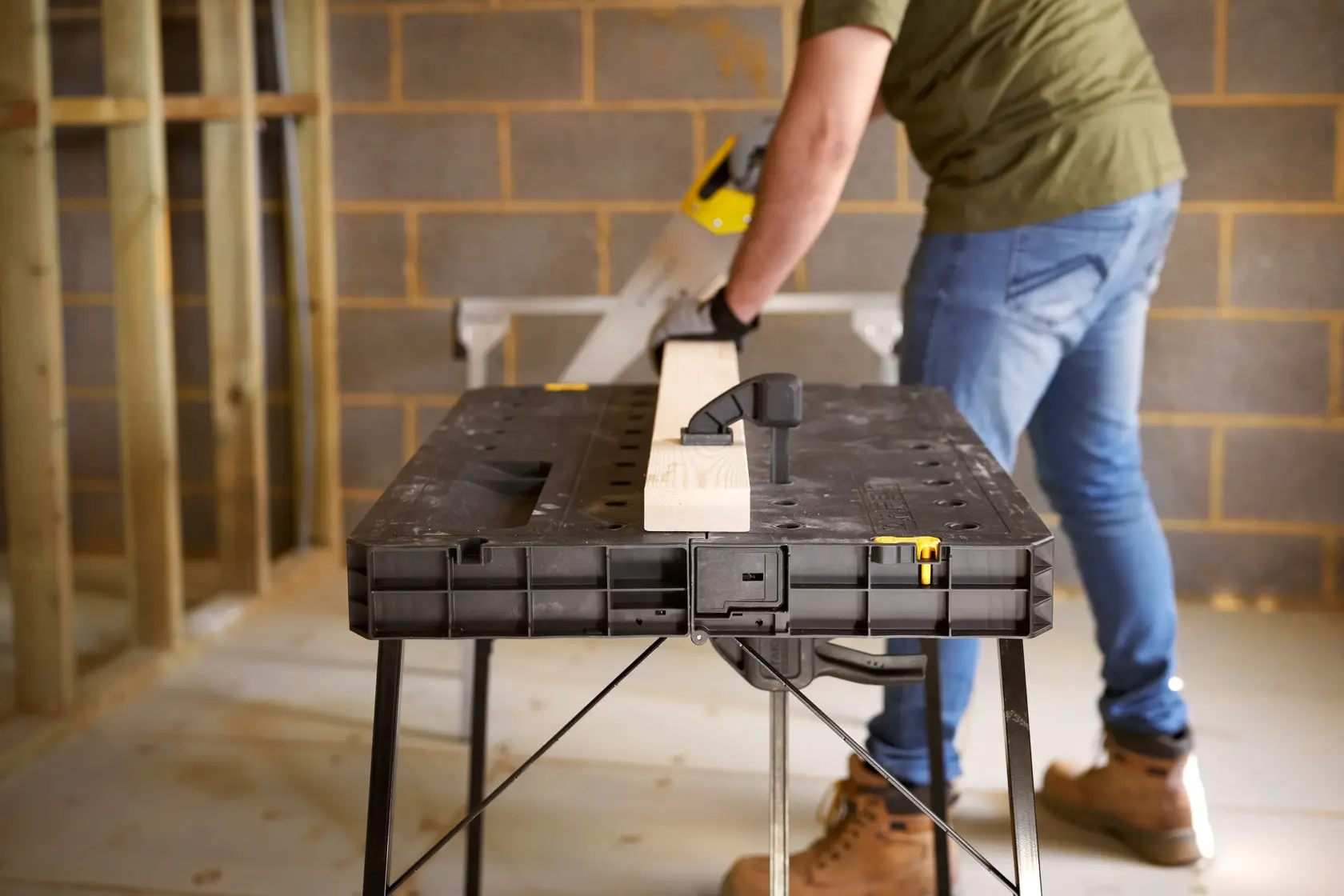 STANLEY STST11552 banco de trabajo con madera sujeta, fotografía del producto en uso en obra.