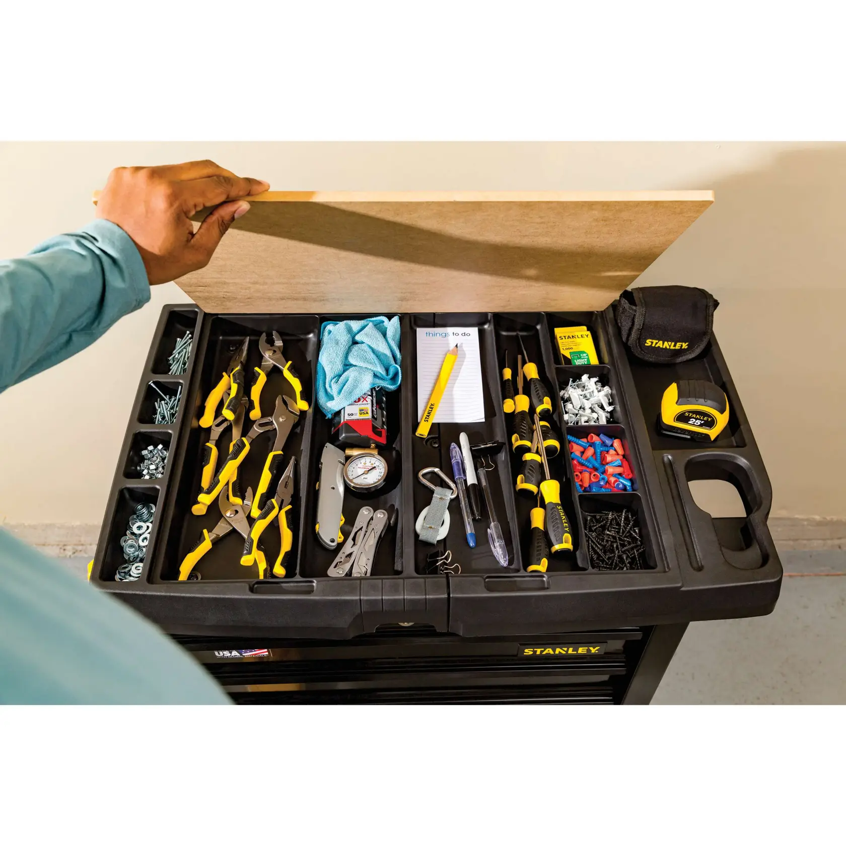 STANLEY STST23151BK vista superior del organizador de herramientas con la tapa abierta, herramientas amarillas y negras, tornillos y cinta métrica.