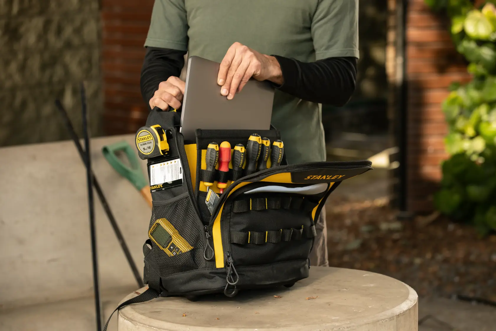Foto de la mochila para herramientas STANLEY STST515155LA con herramientas y laptop, en interior, vista frontal.