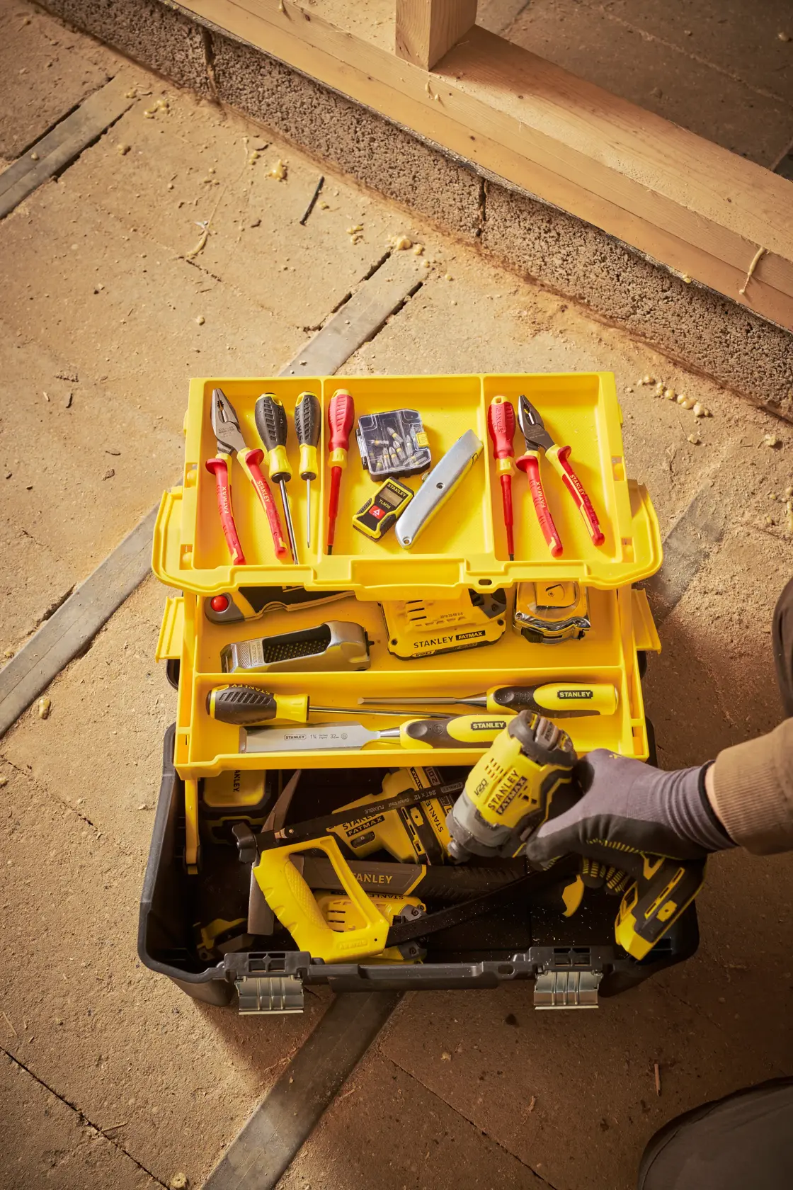 Stanley STST83397-1 caja de herramientas con herramientas de mano variadas, bandeja amarilla y herramienta eléctrica, vista superior.