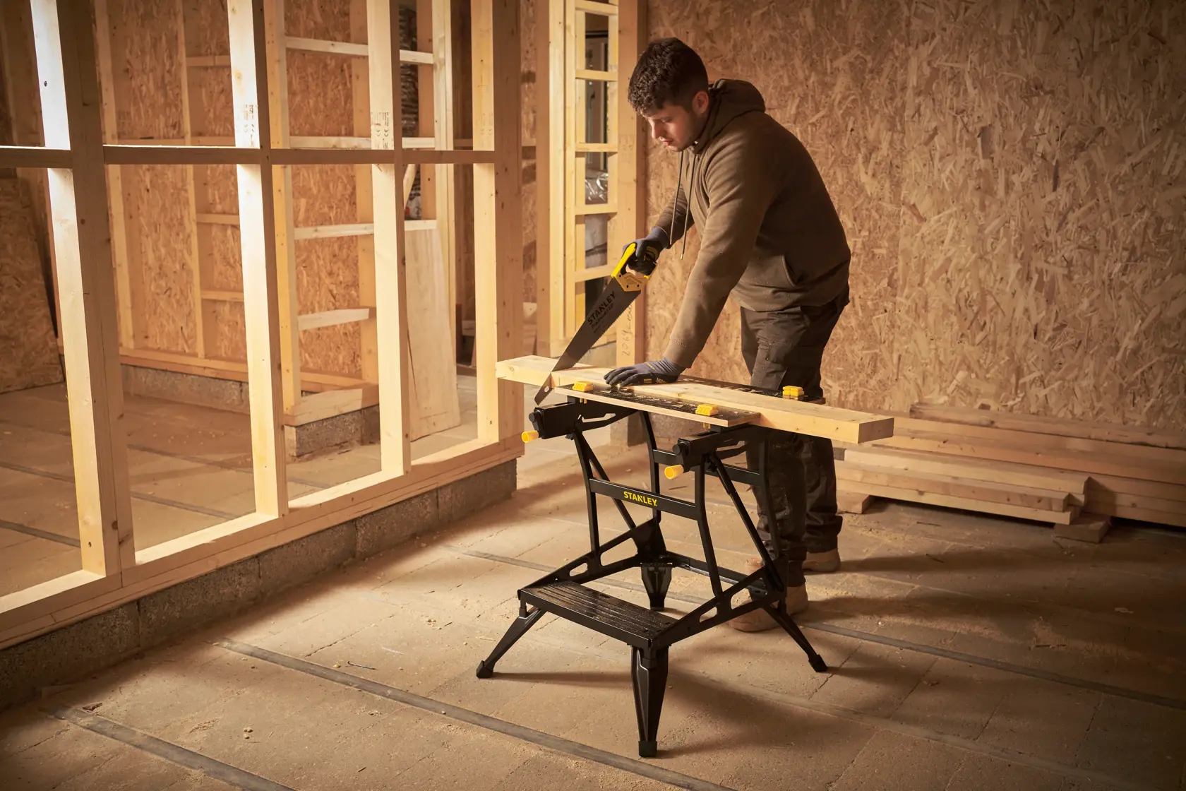 STANLEY STST83400-1 caballete utilizado, sosteniendo una tabla de madera en obra en construcción.