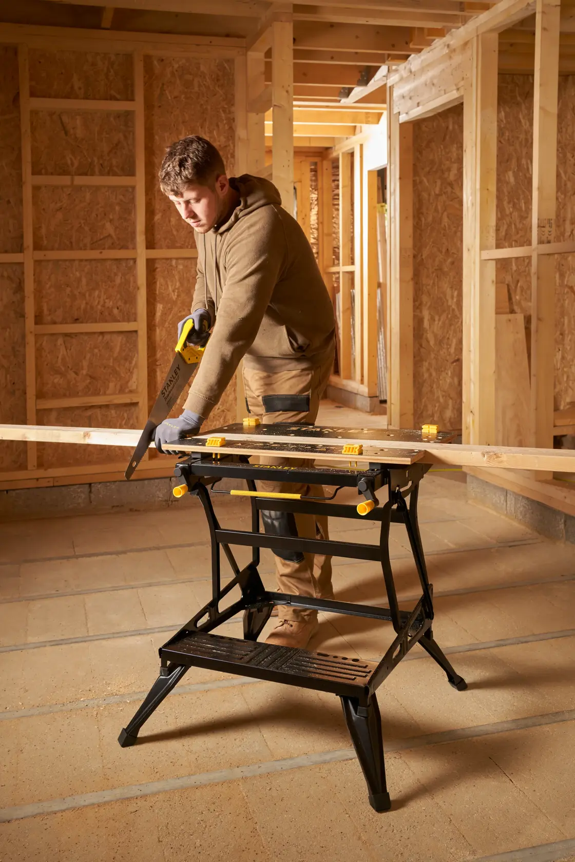 STANLEY STST83800-1 banco de trabajo en uso en obra, sostiene tabla de madera, categoría fotografía.
